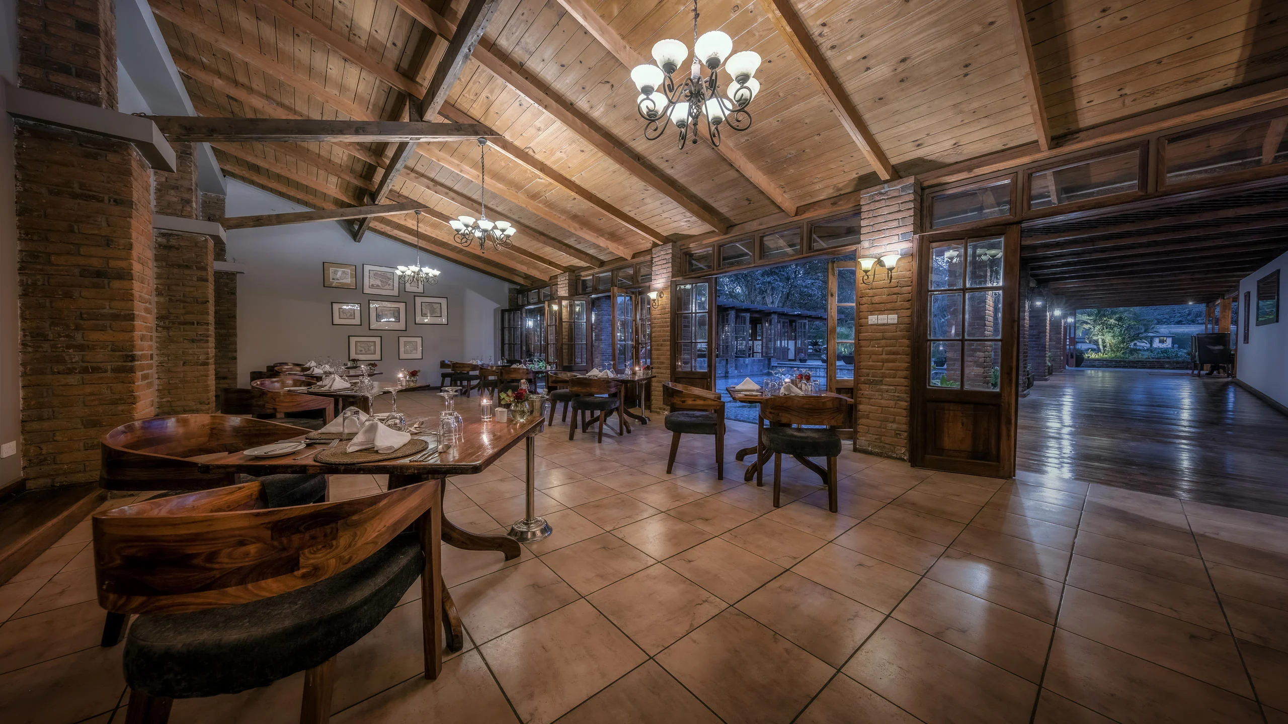 The dining room with timber beams and a chandelier