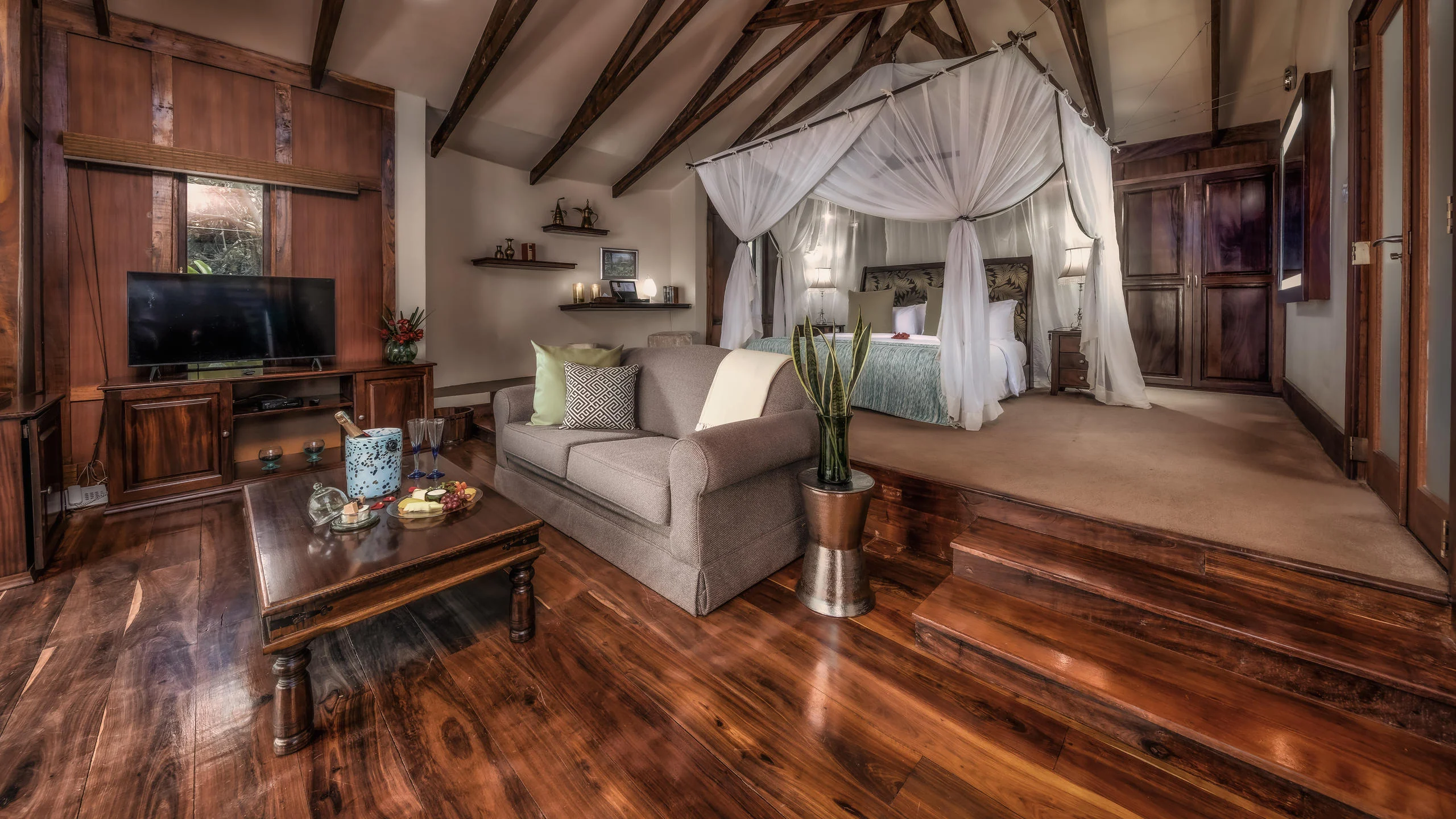 A suite sitting room with the bed beyond