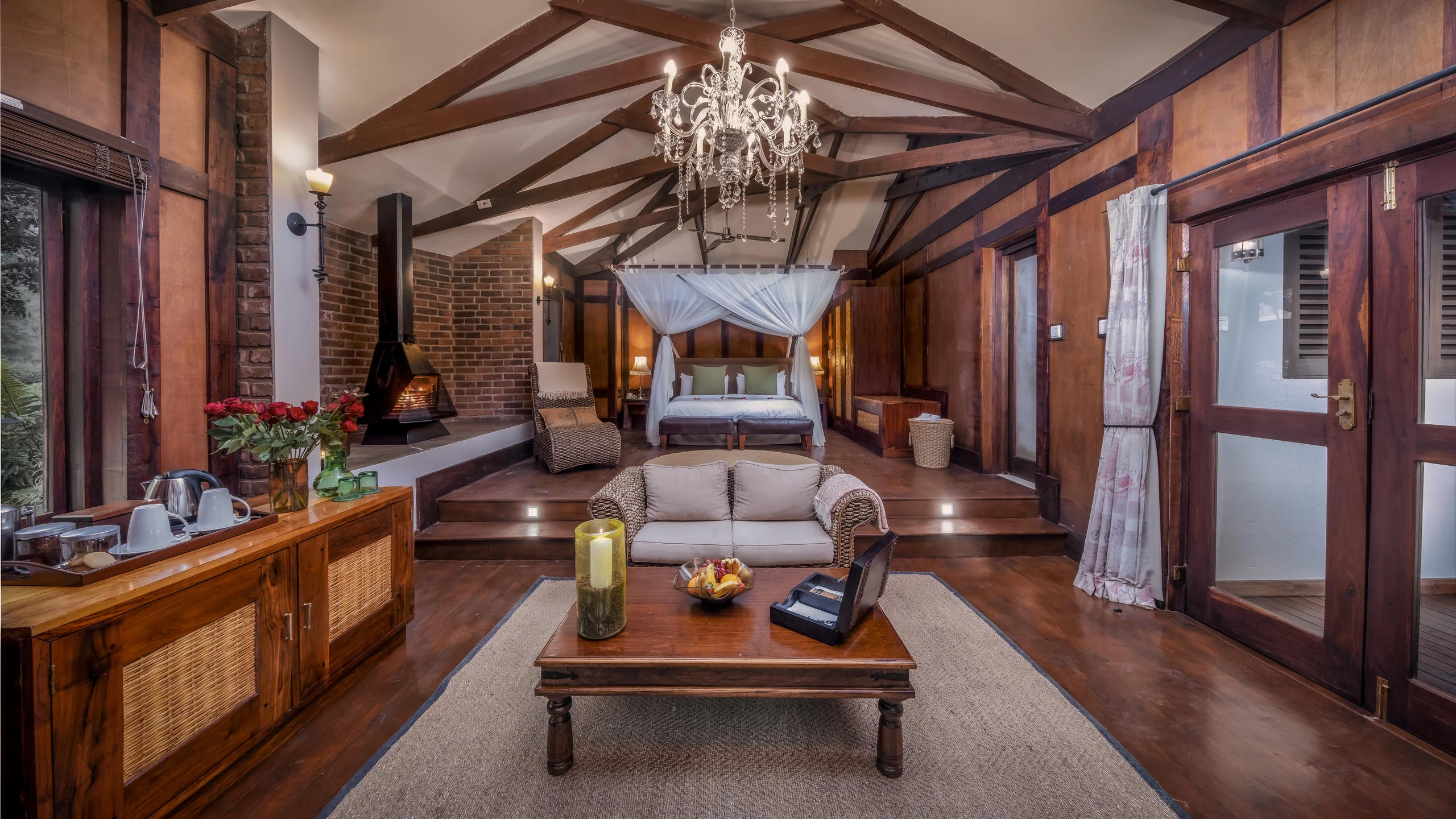 A suite with a fireplace, sitting area and four-poster bed