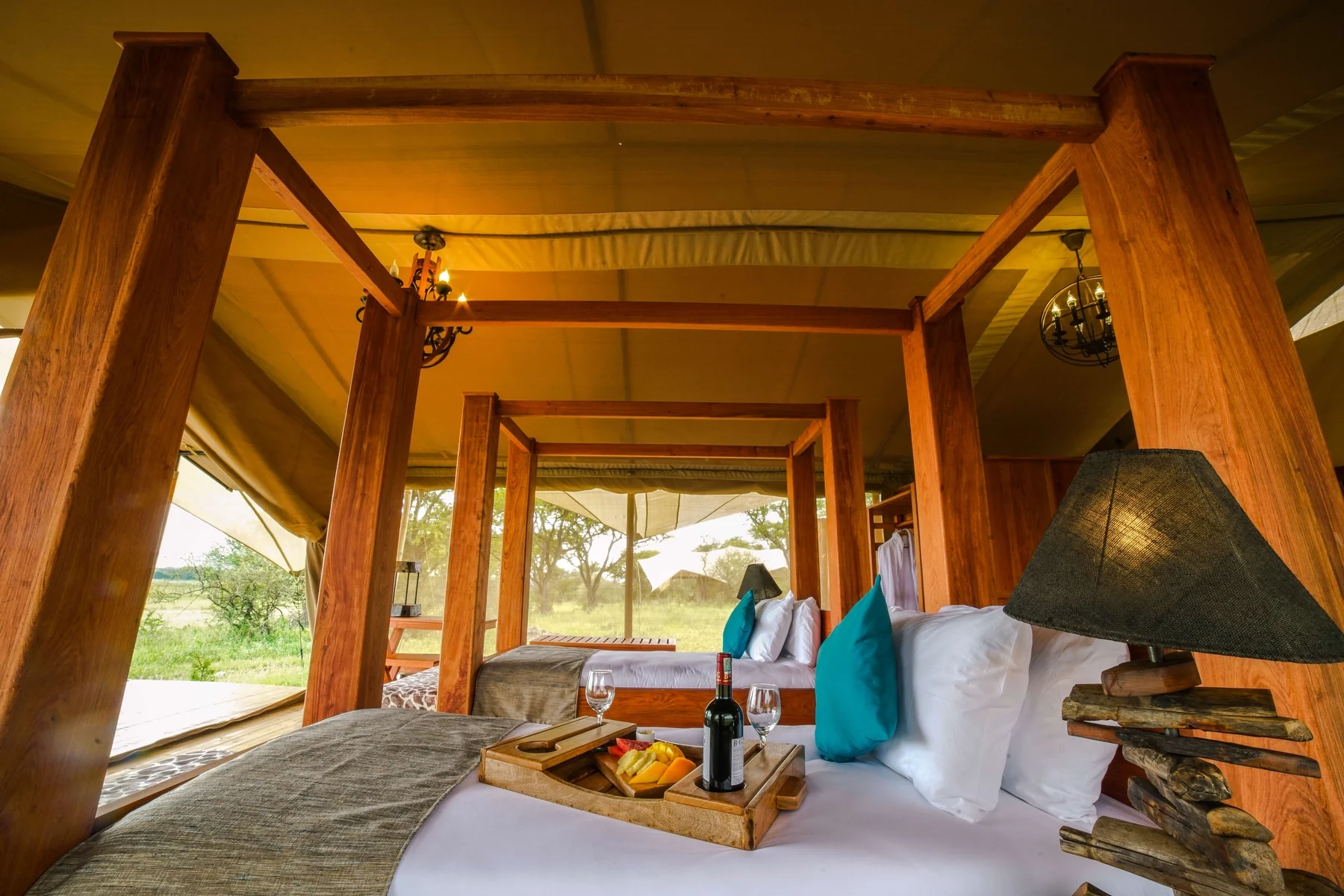 A tent bedroom with a canopied bed and a breakfast tray