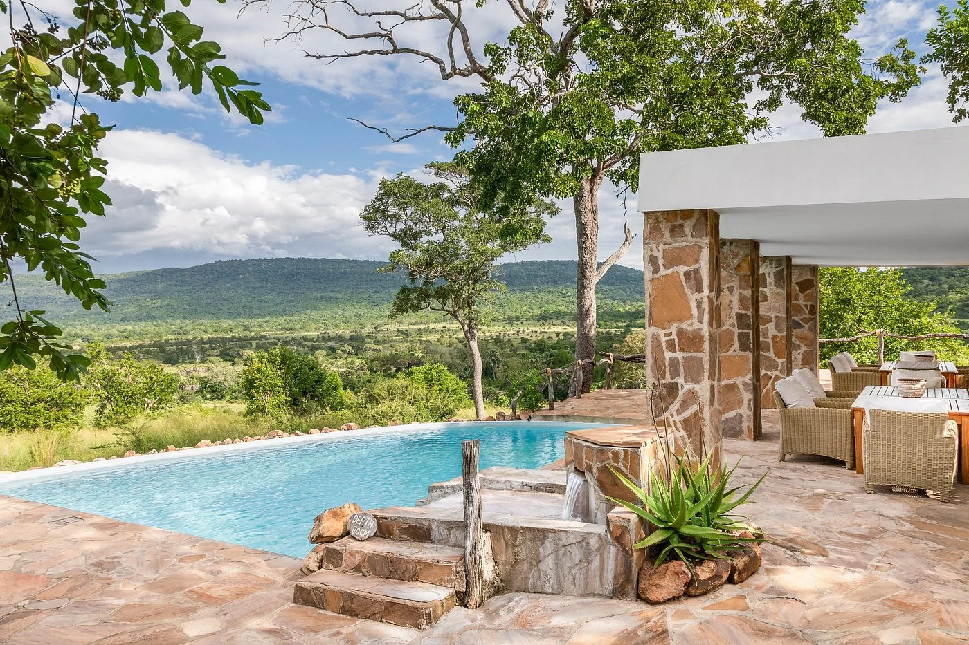 The pool and a stone-built banda with the plains beyond