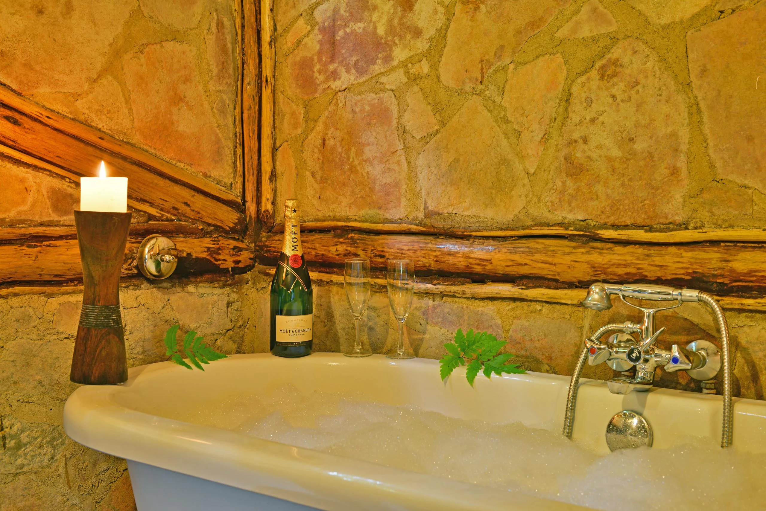 A bath with a candle and a bottle of wine