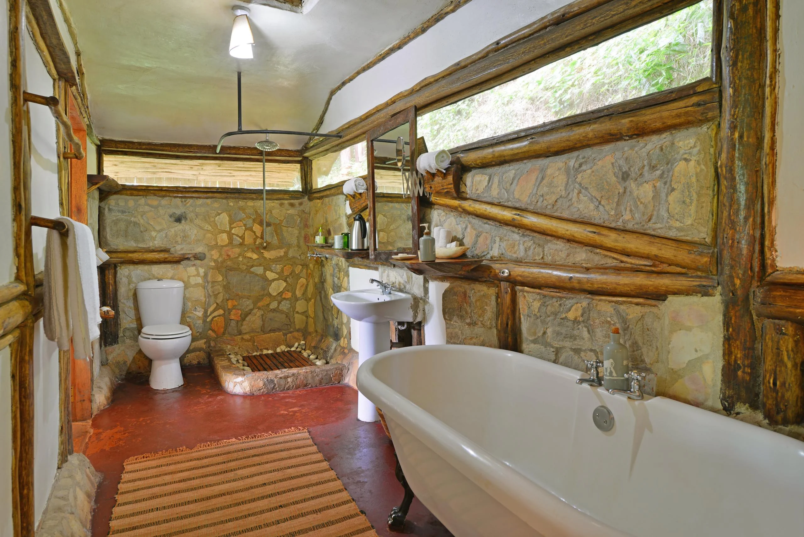 A bathroom with a bath and stone walls