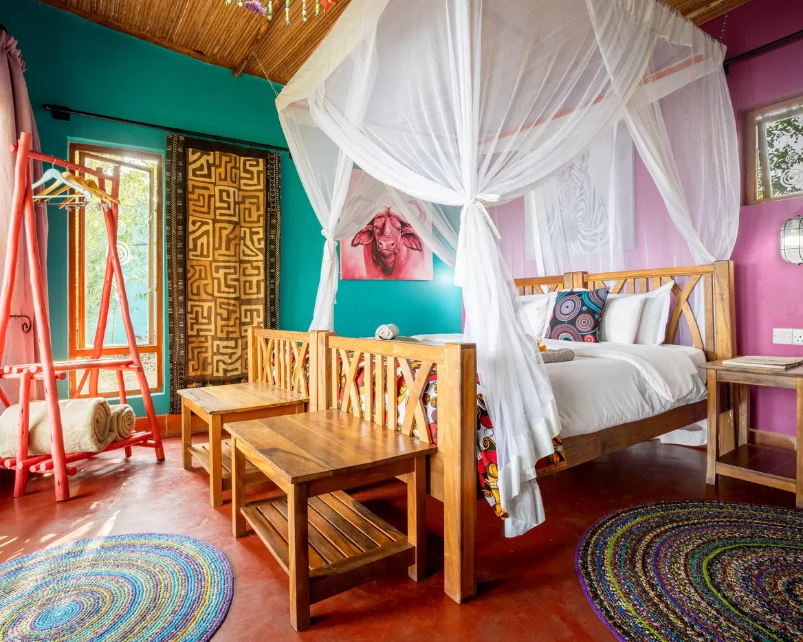 A brightly painted bedroom with a draped bed