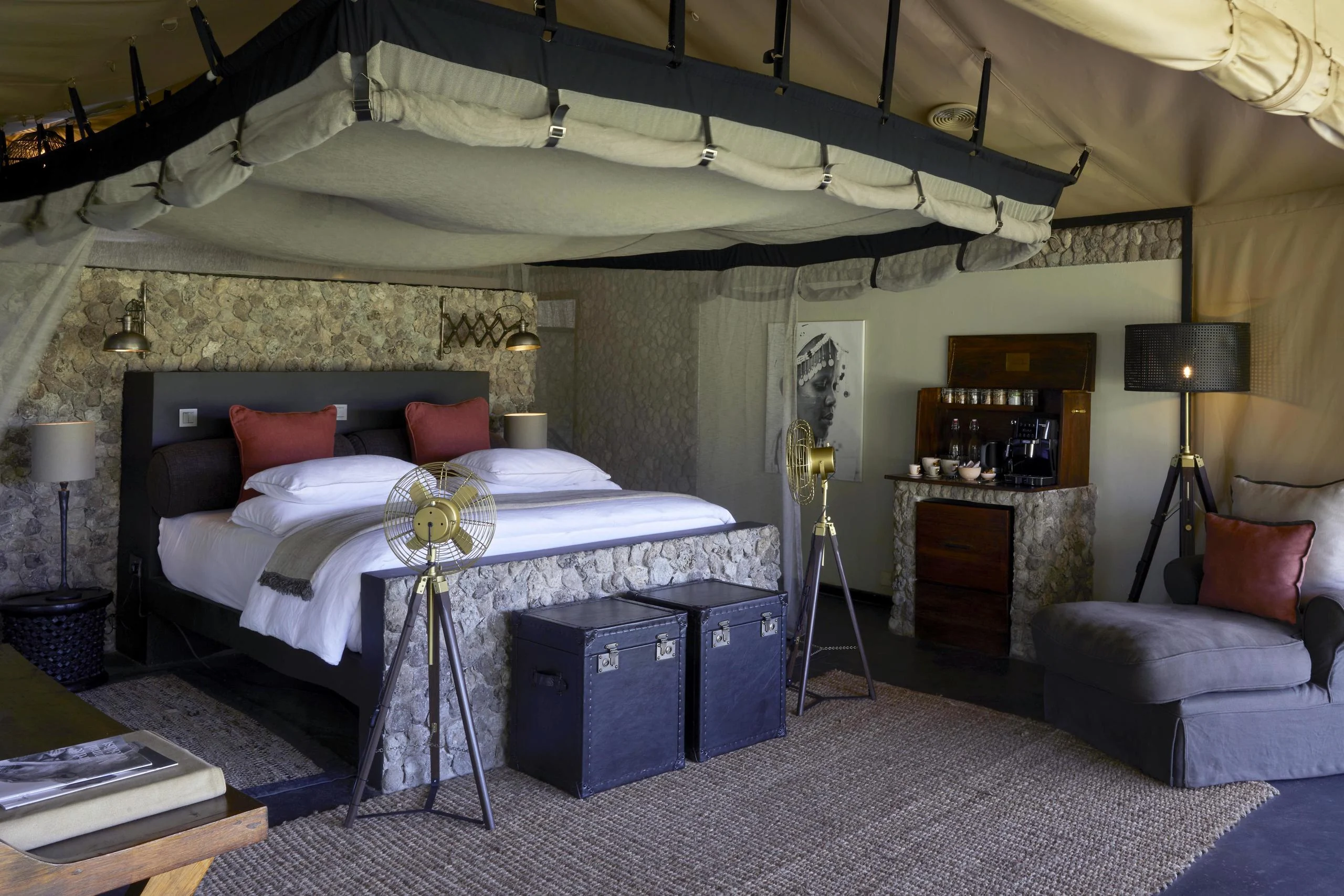 A tent bedroom with a bed and a drinks cabinet