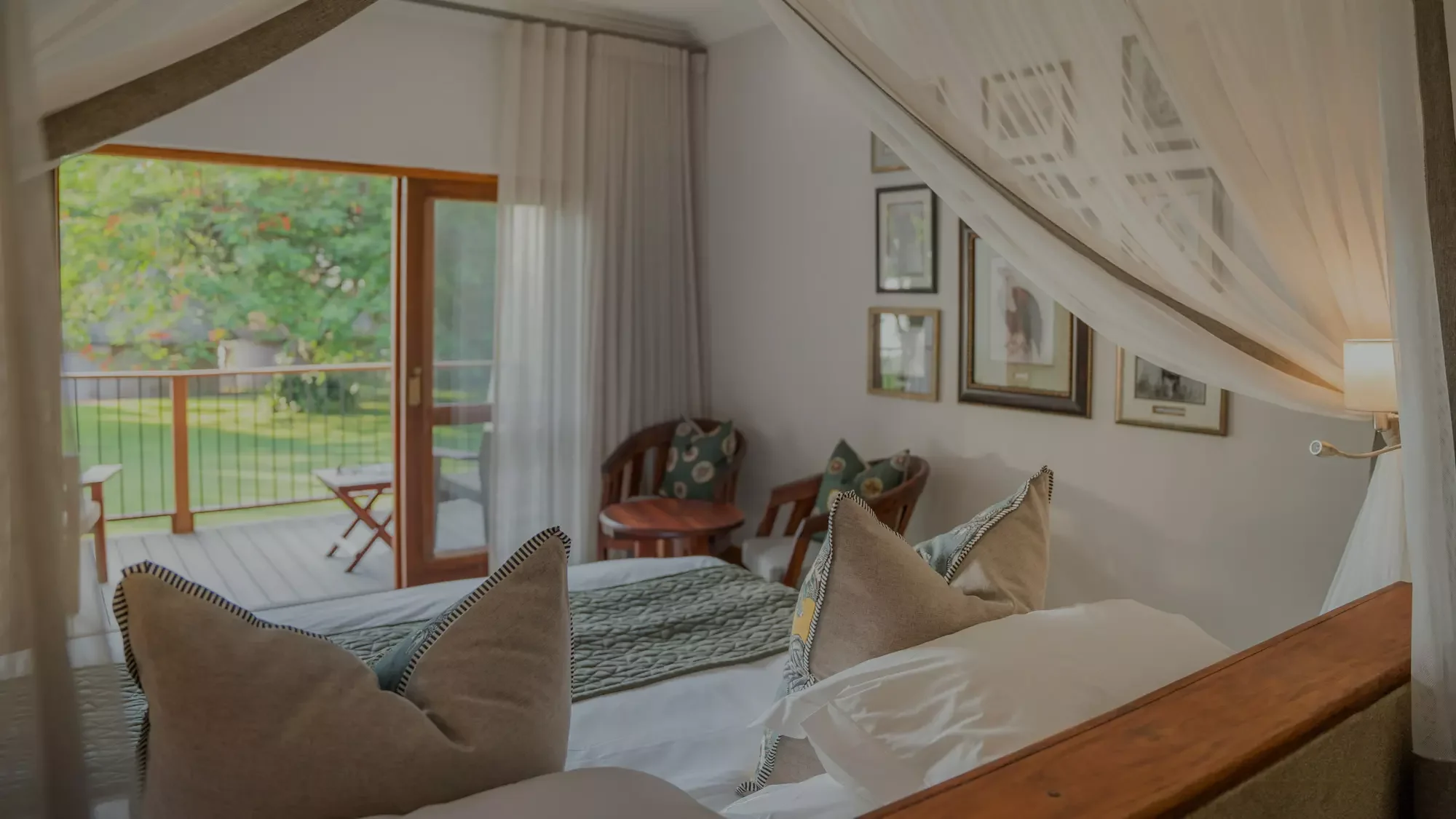 A bedroom with a draped bed and doors onto the garden