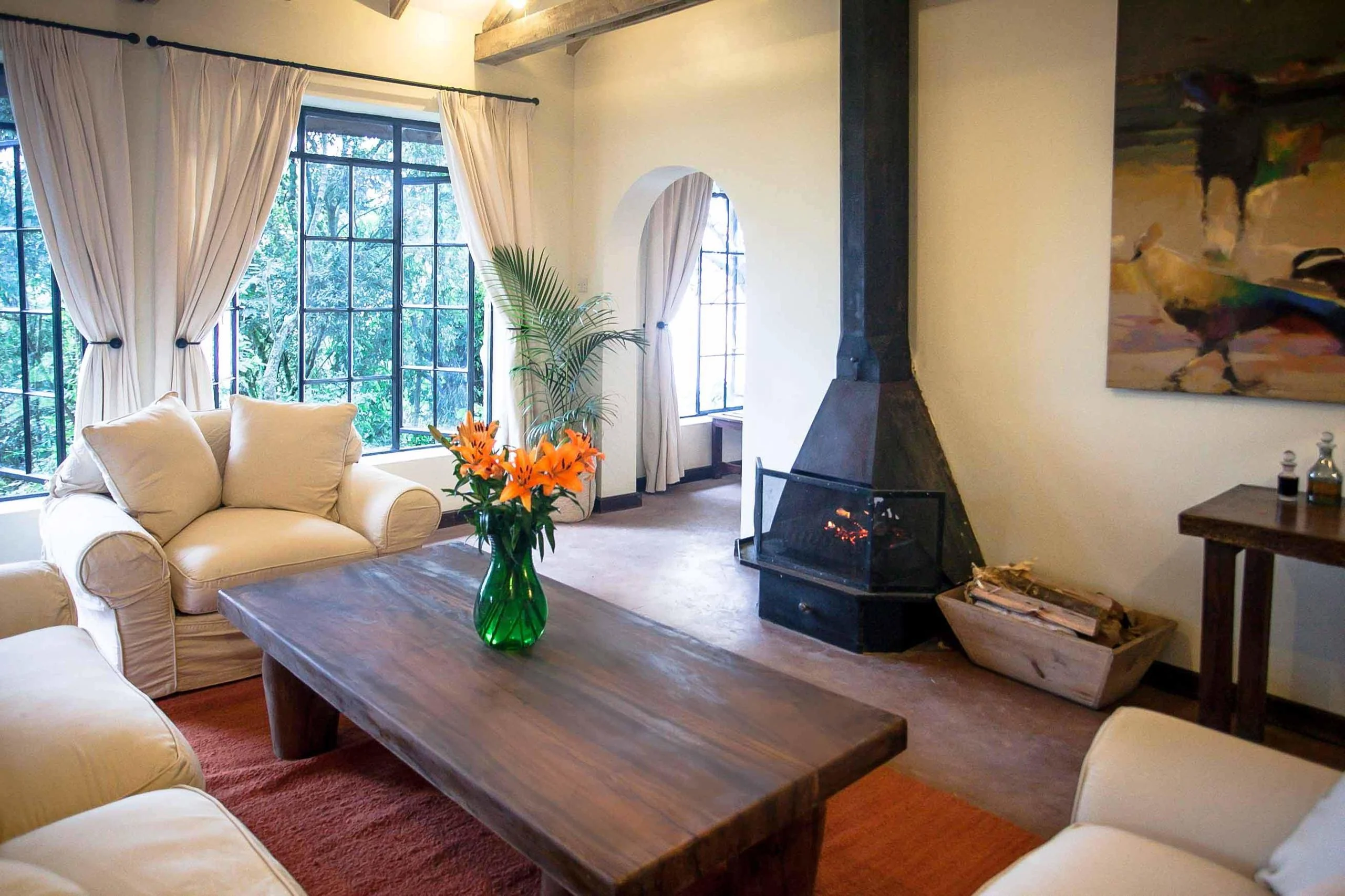 A cottage sitting room with a stove and armchairs