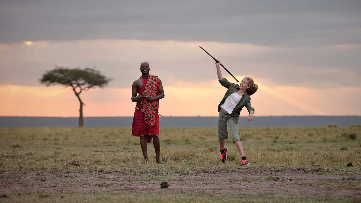 A Maasai guide and a guest on the plains at sunset