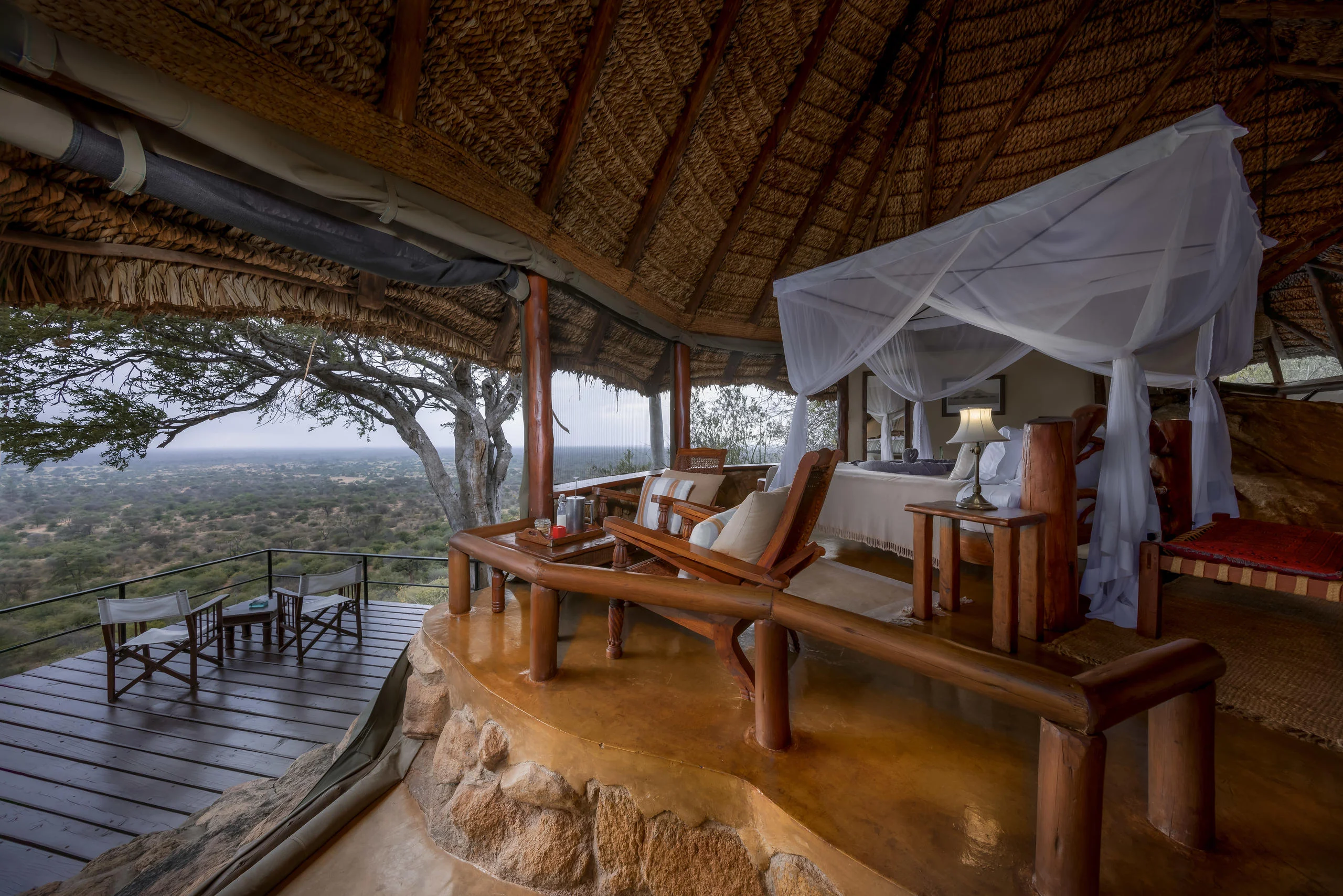 A cottage bedroom under thatch with the deck beyond