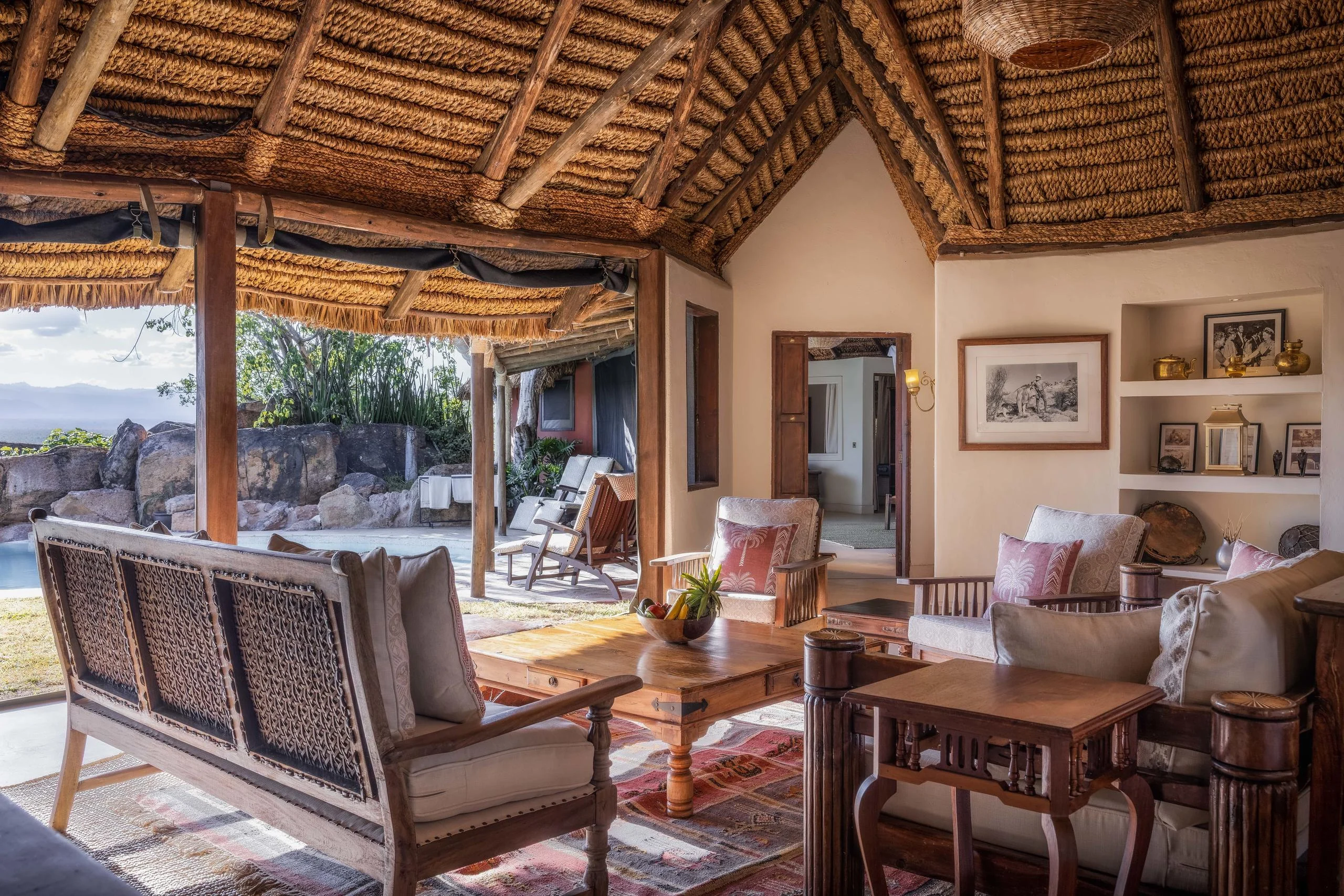 The lounge under thatch with sofas and bookshelves