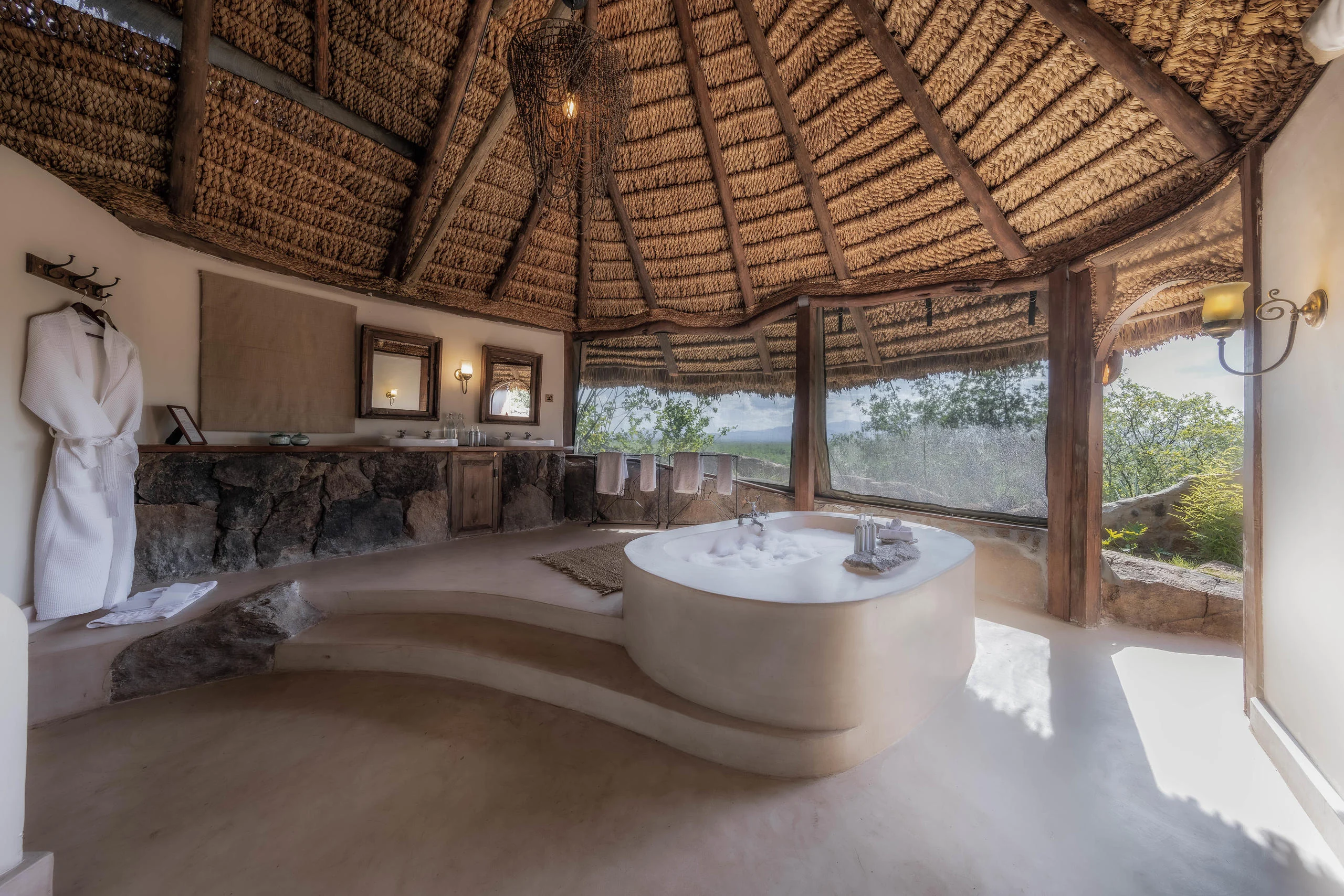 A bathroom with a bath set into the rock