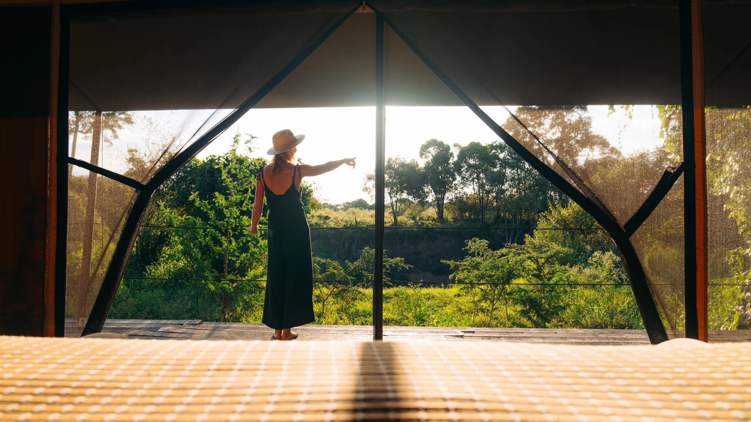 A guest on a tent deck at sunset