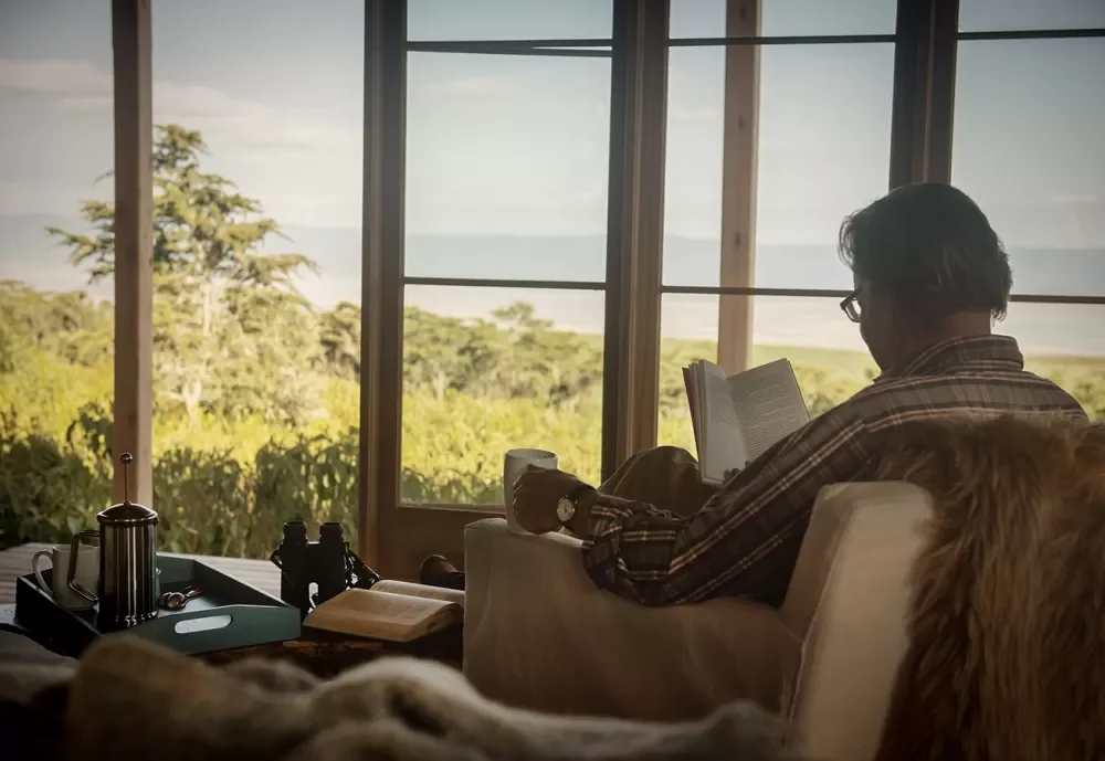 A guest reading beside the window with the view beyond