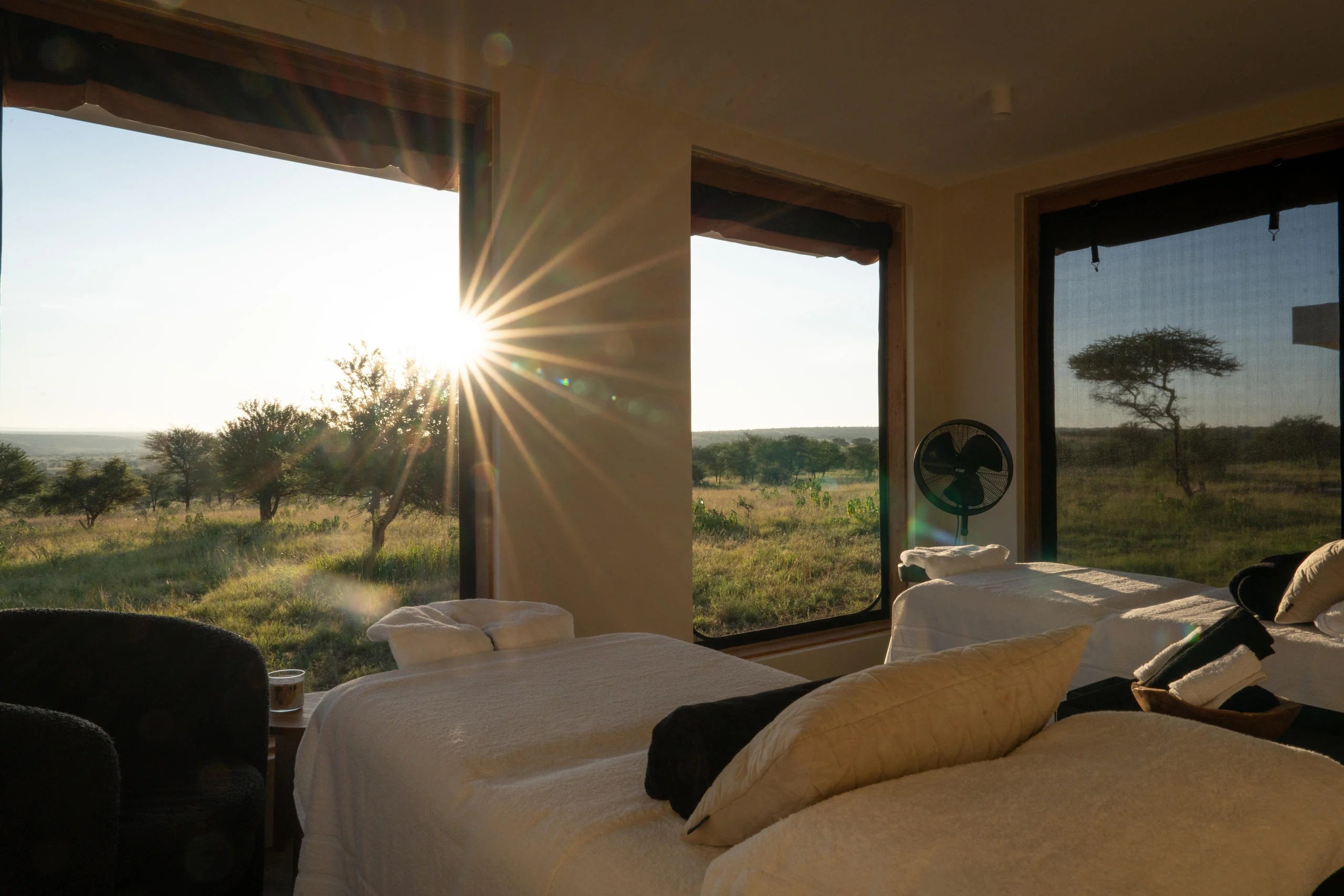 A bedroom at sunrise with the plains beyond
