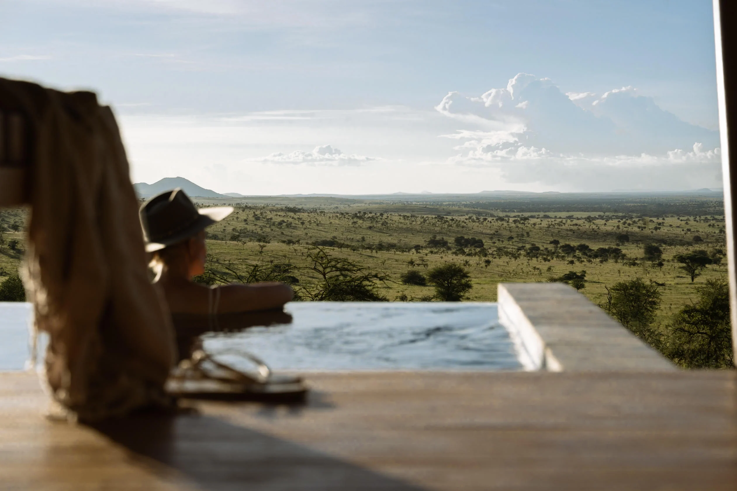 A guest beside the pool looking over the plains