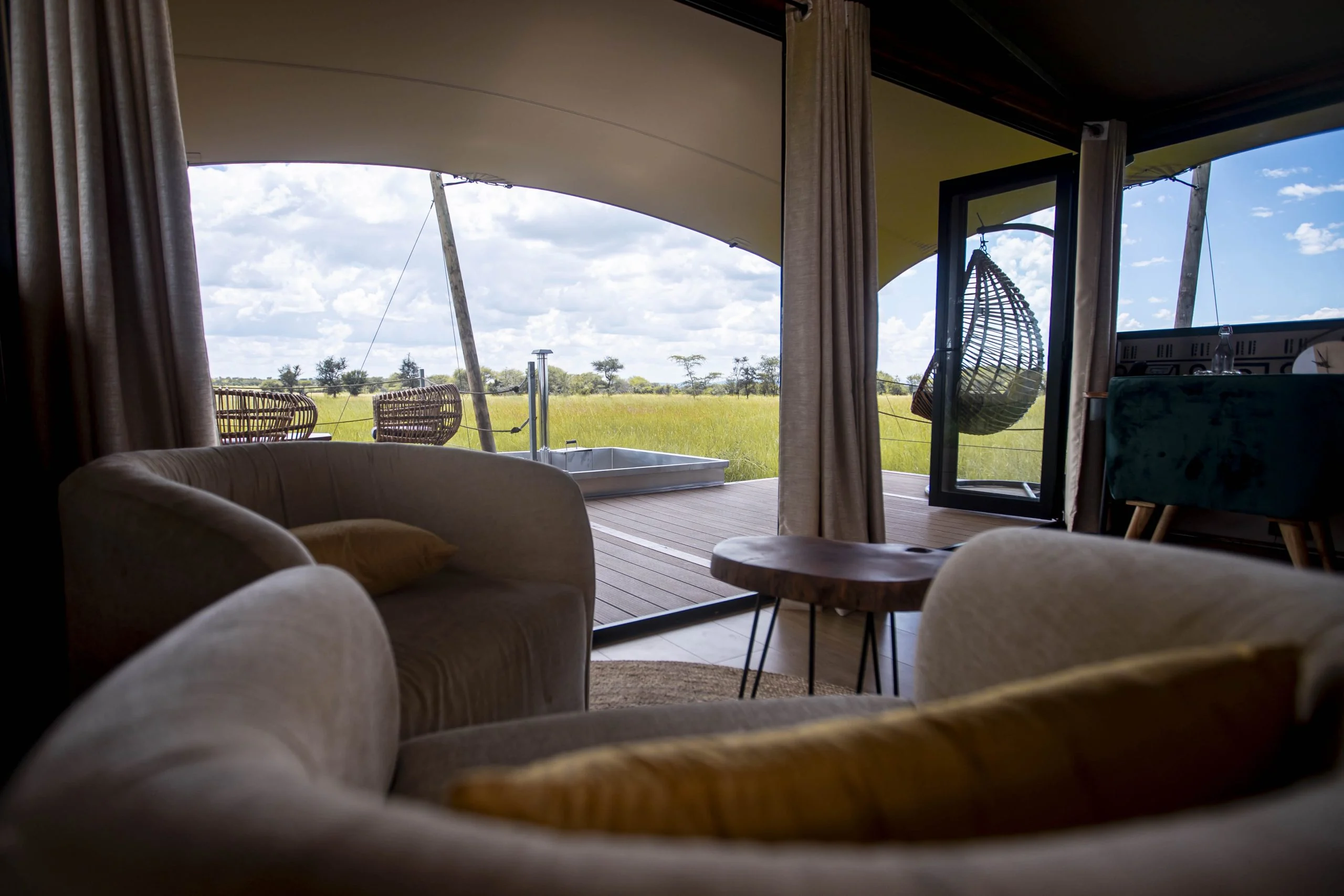 The sitting area of a suite, with a hanging chair on the deck