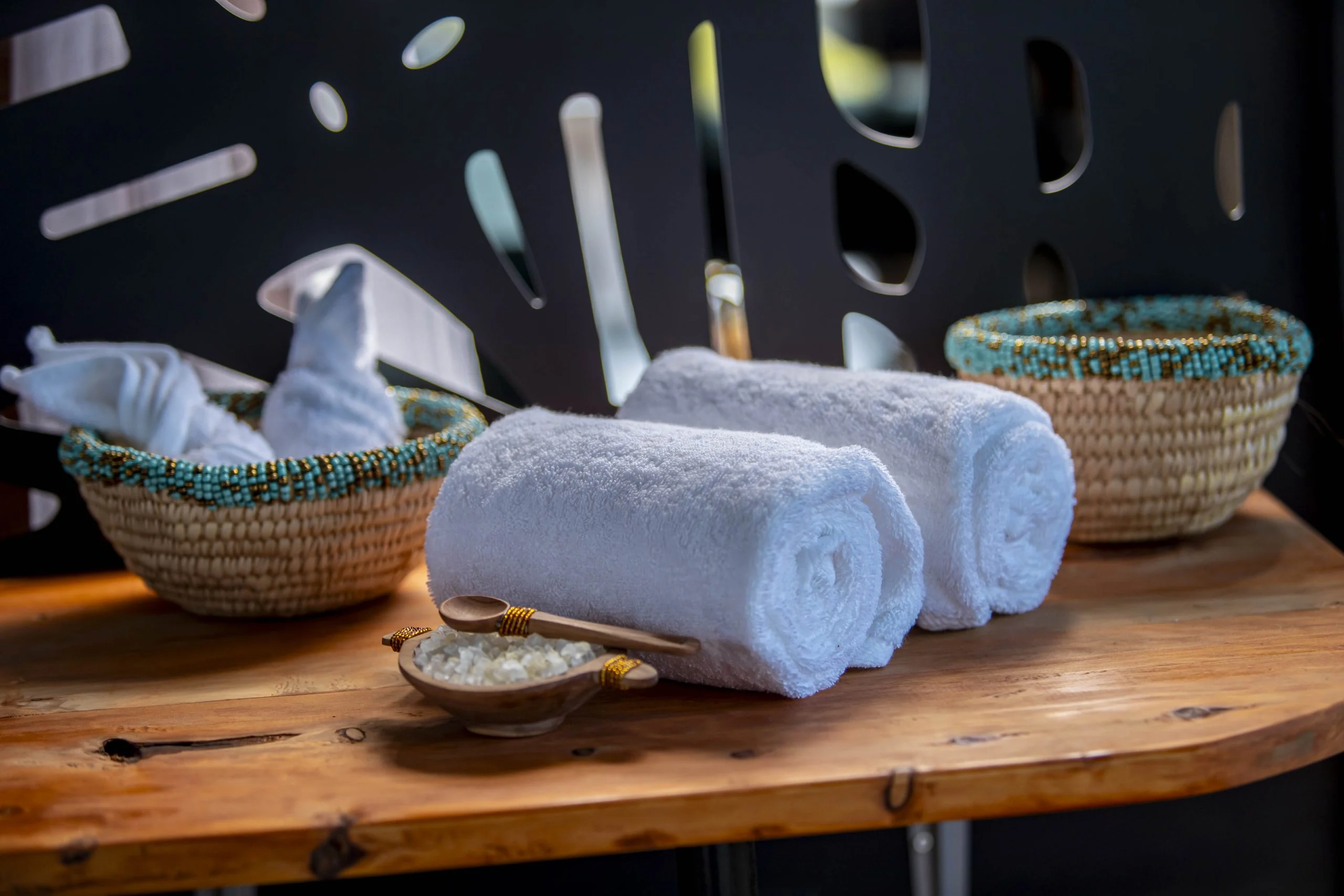 Rolled towels and baskets on a timber shelf