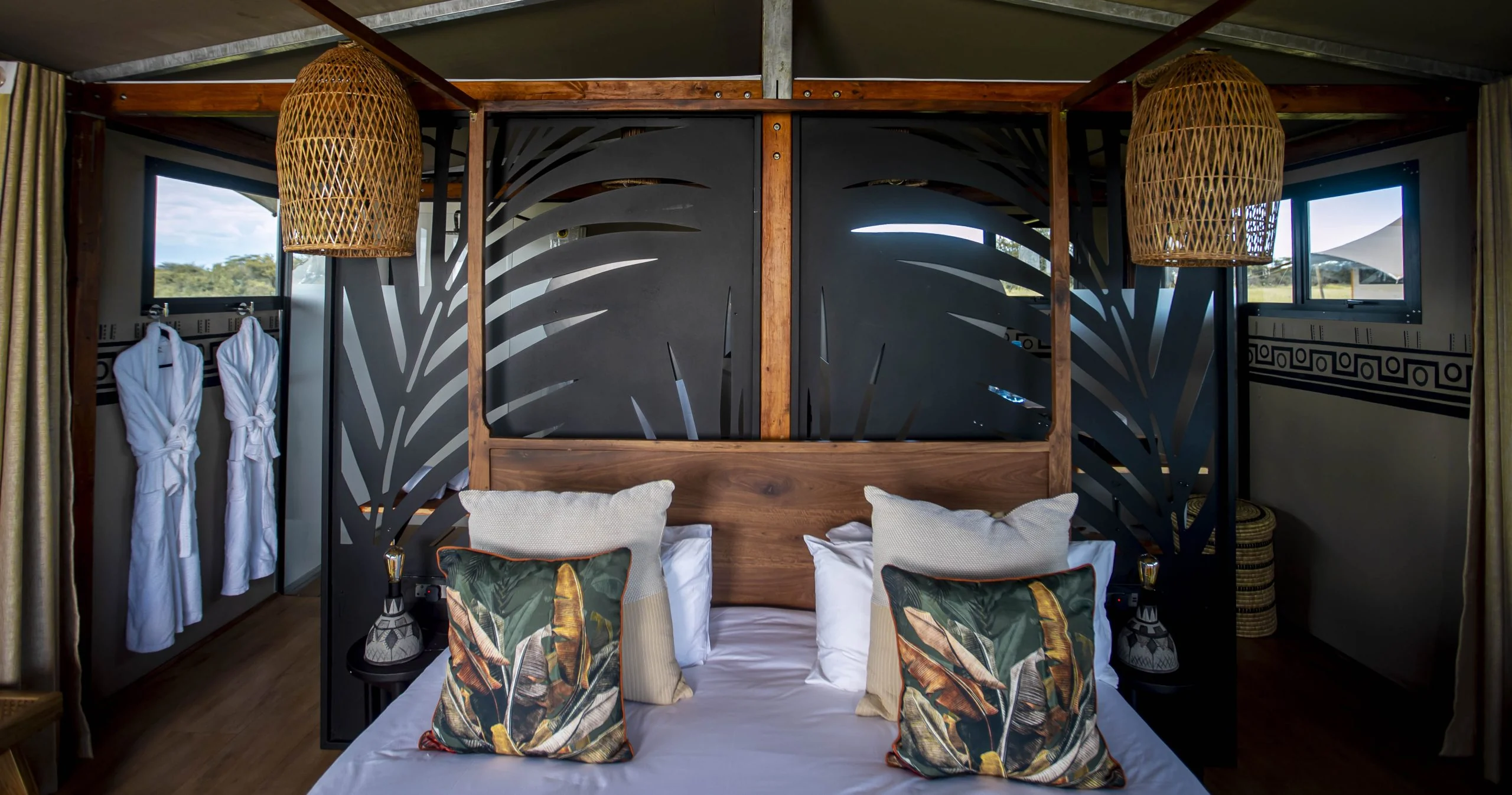 A bedroom with a patterned headboard and hanging lamps