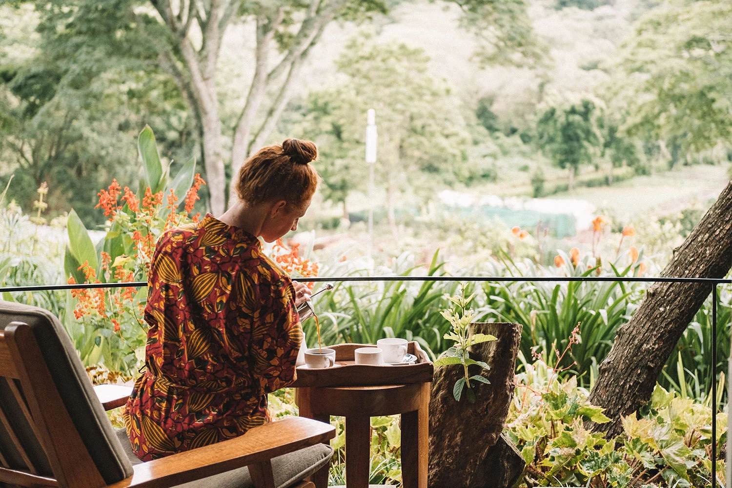 A guest at a table on the veranda, looking over the garden