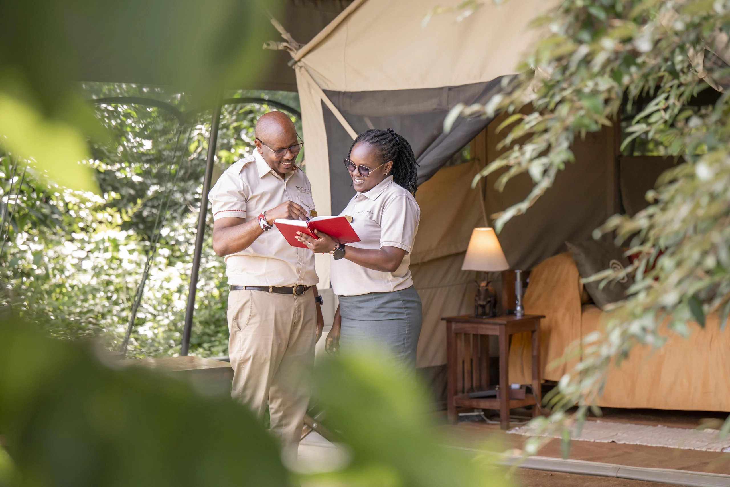 Two members of staff outside a tent