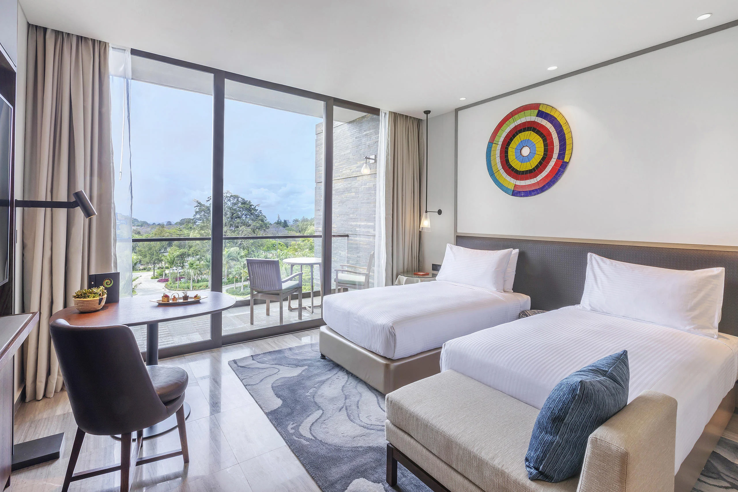 A twin bedroom with a balcony and city views