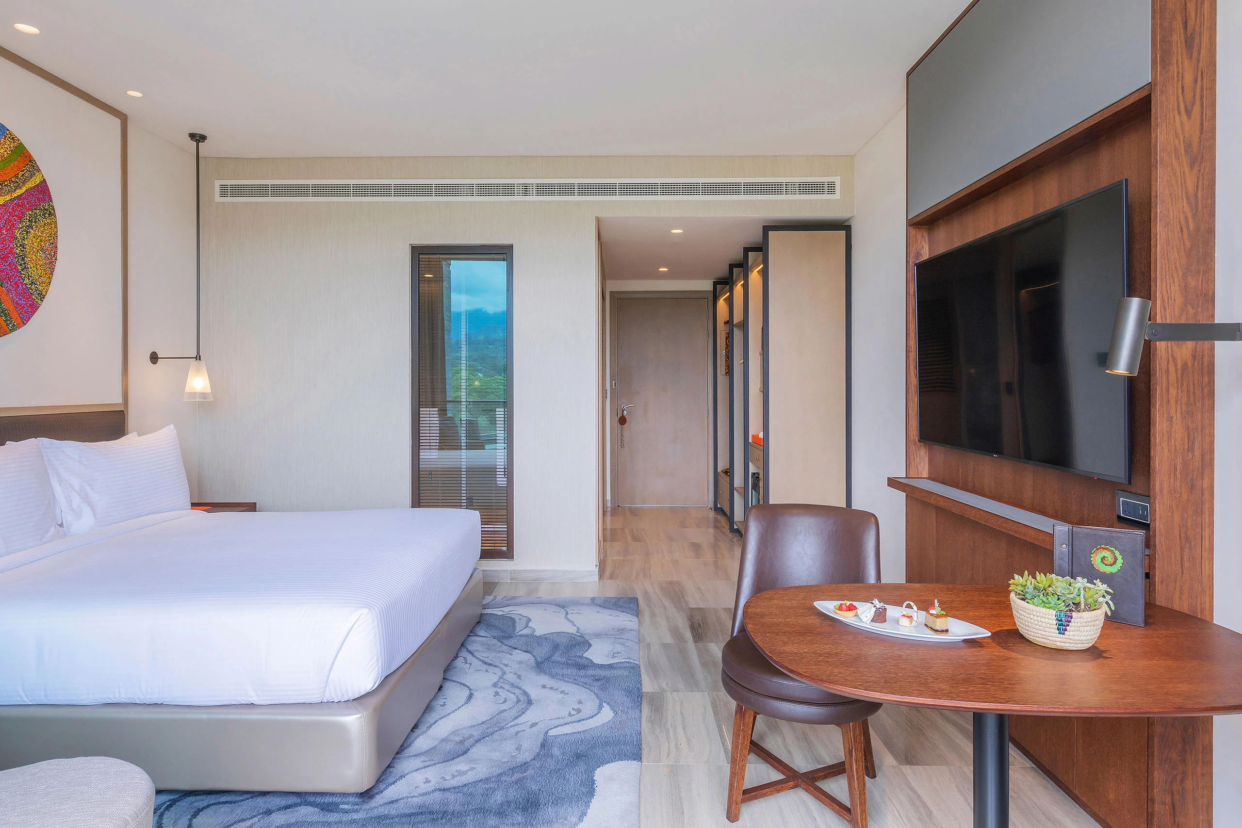 A bedroom with a desk and a wall hanging