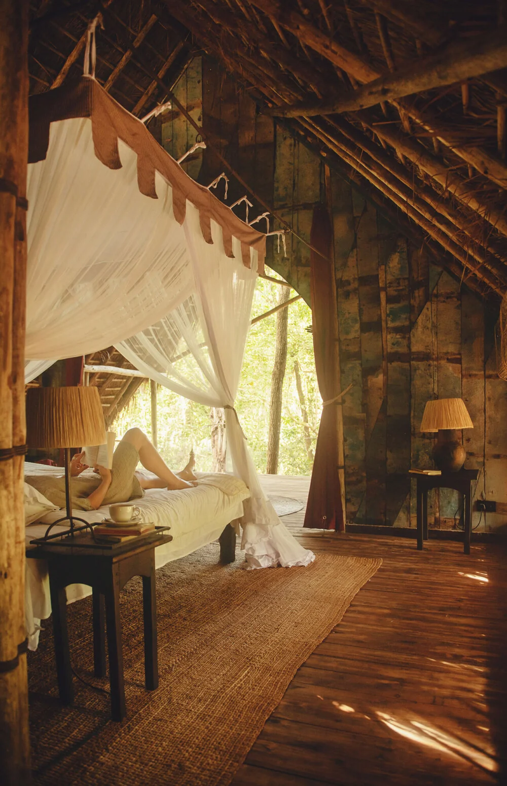 A guest reading in a thatched banda