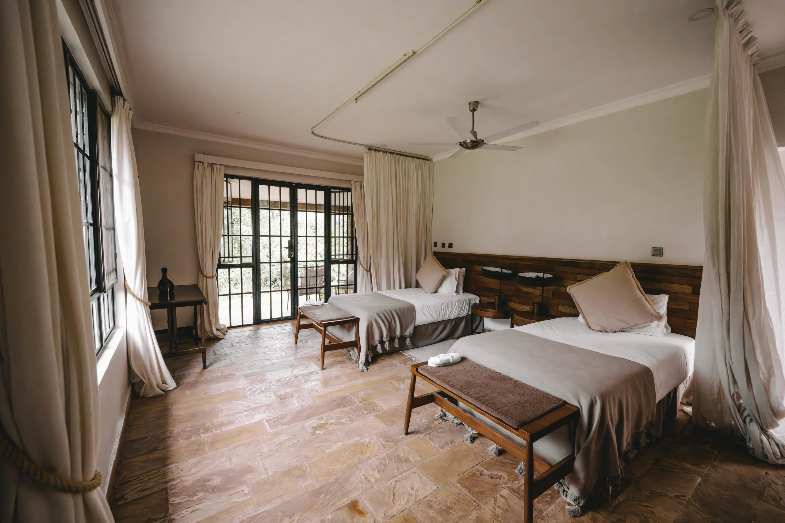 A bedroom with a canopied bed and French windows