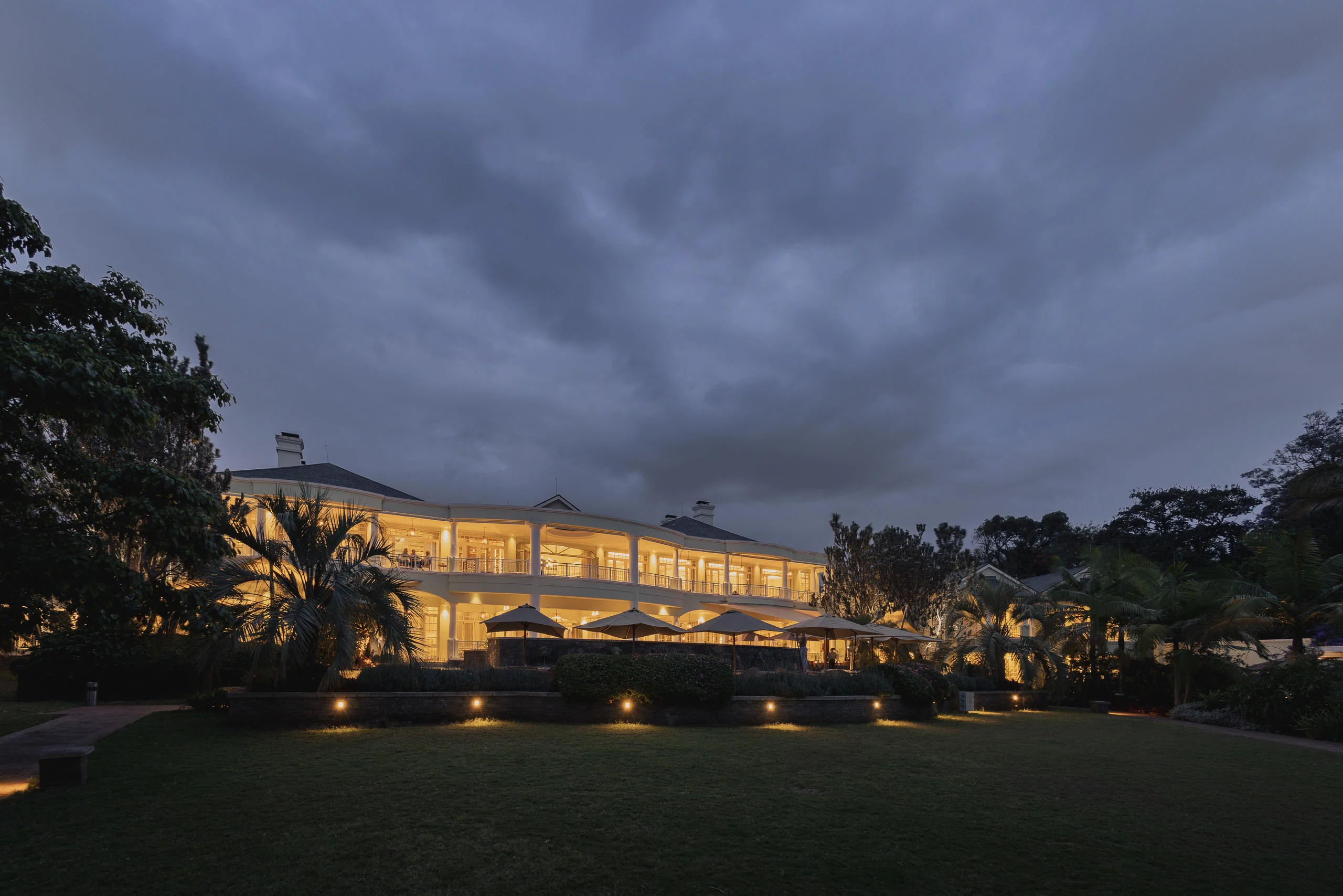 The hotel lit at dusk across the lawn