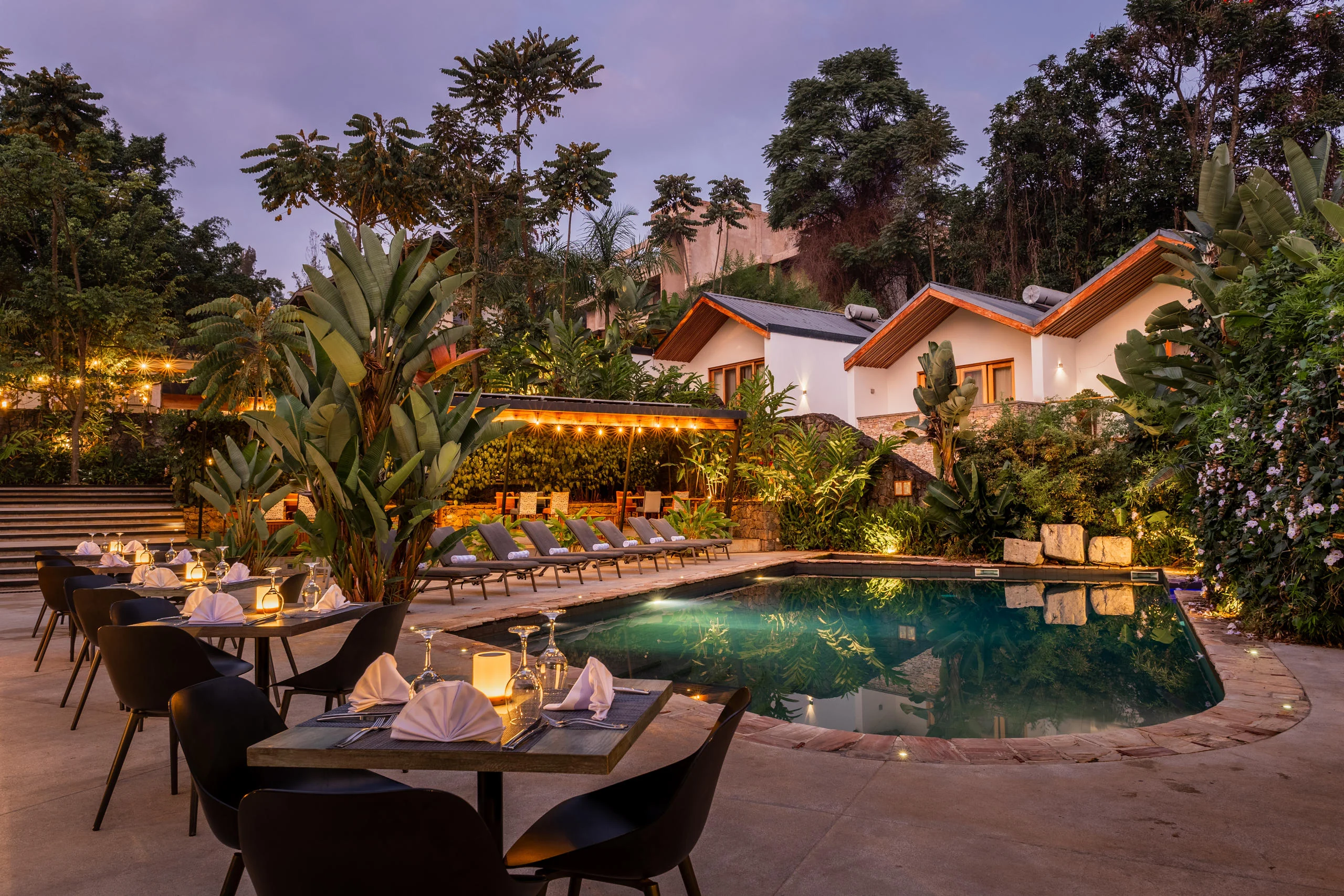 The pool and villas lit at dusk
