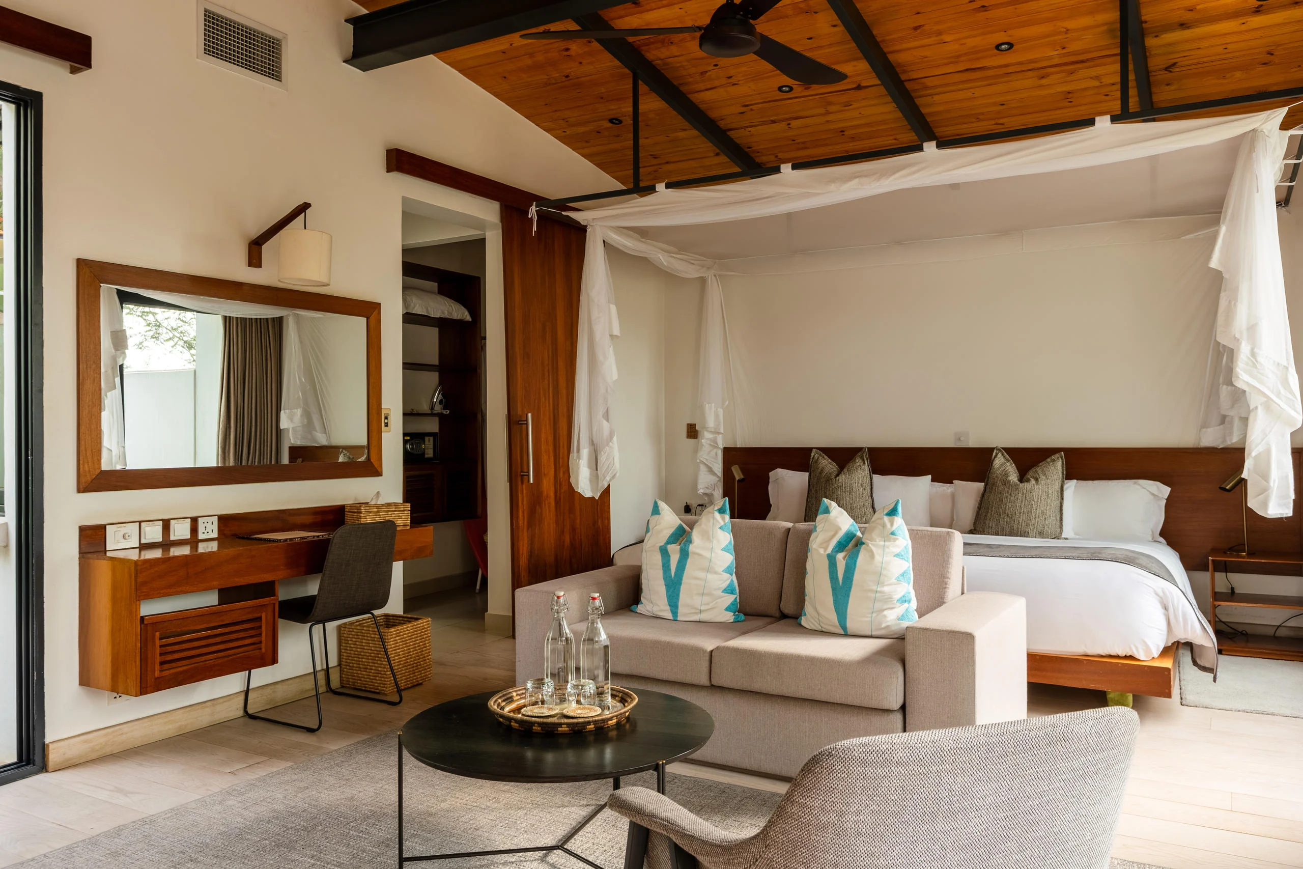 A villa bedroom with a draped bed and a sitting area