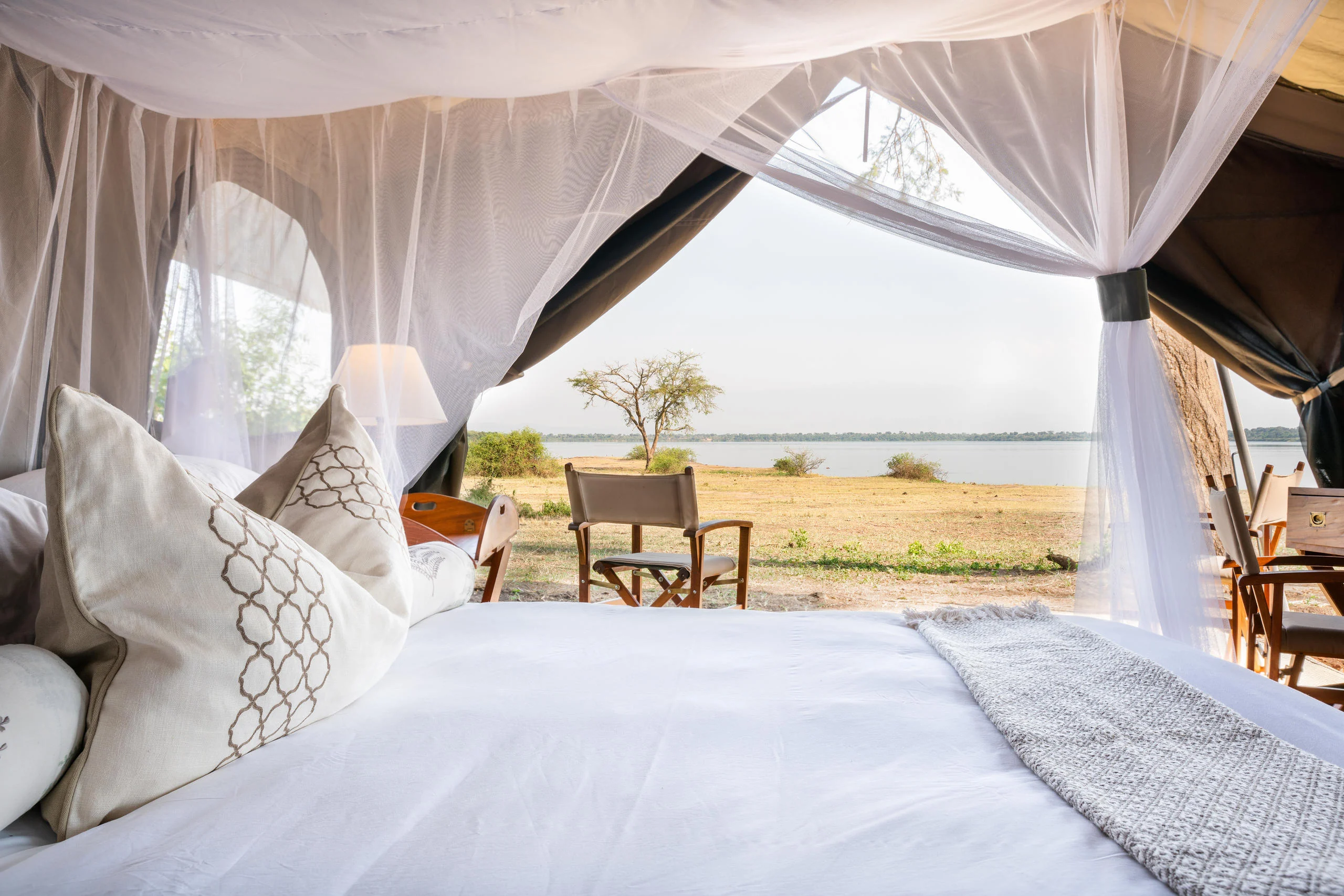 A draped bed looking out to the lake