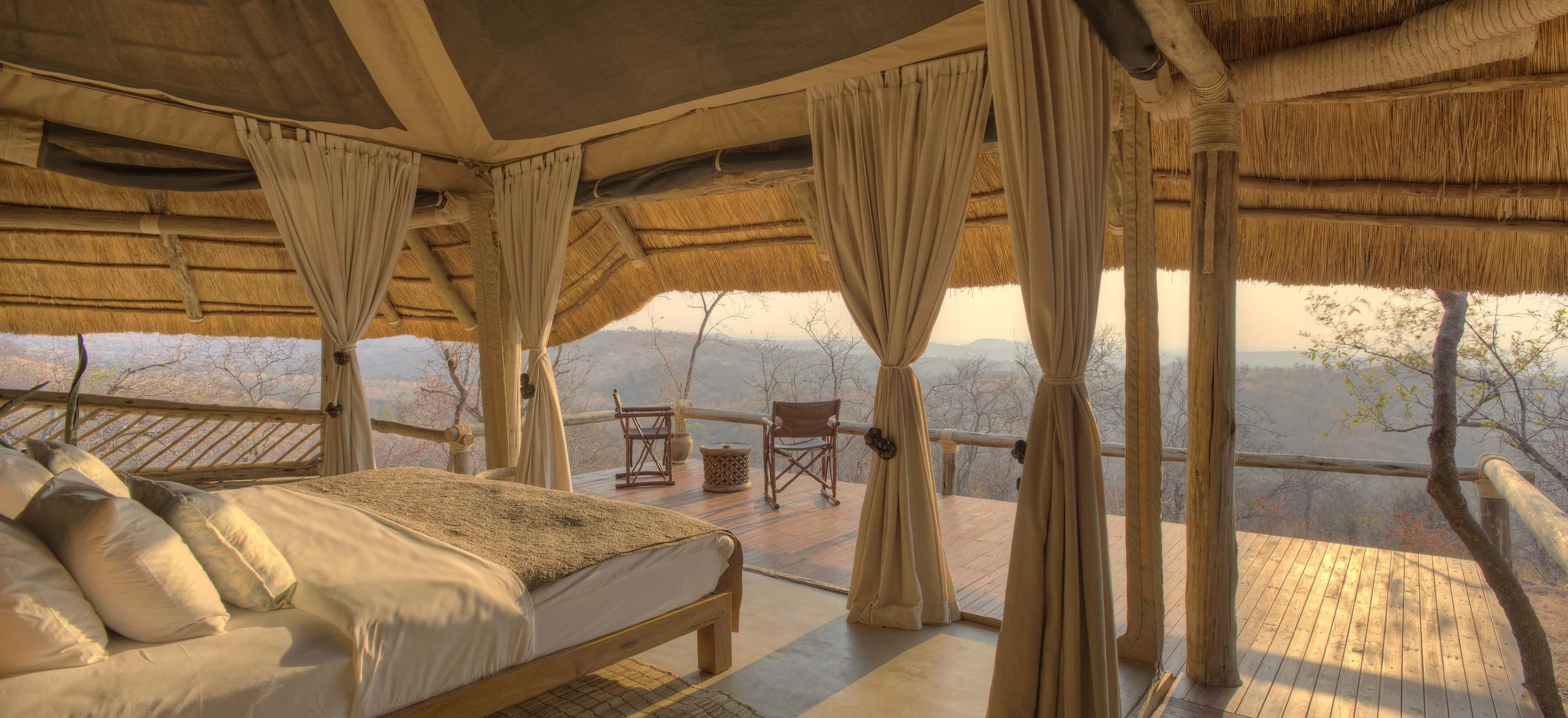 A bedroom with drapes and the view beyond