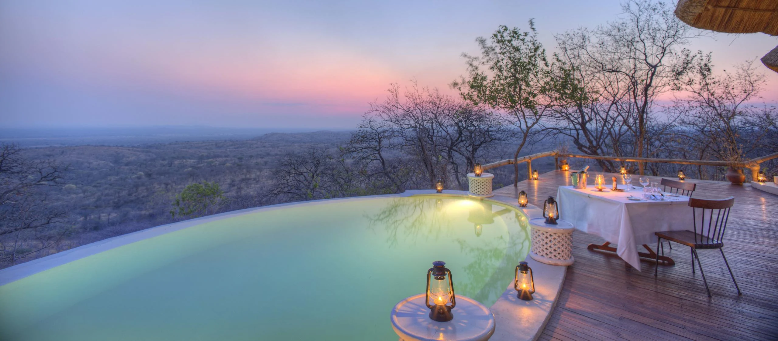 The pool and a table set for dinner at dusk