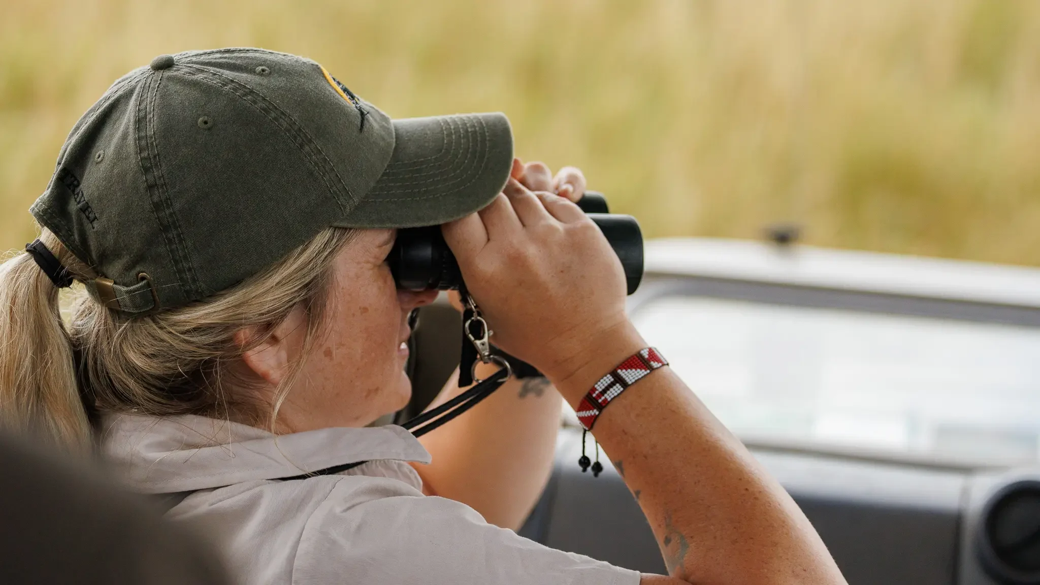A guide with binoculars in a vehicle