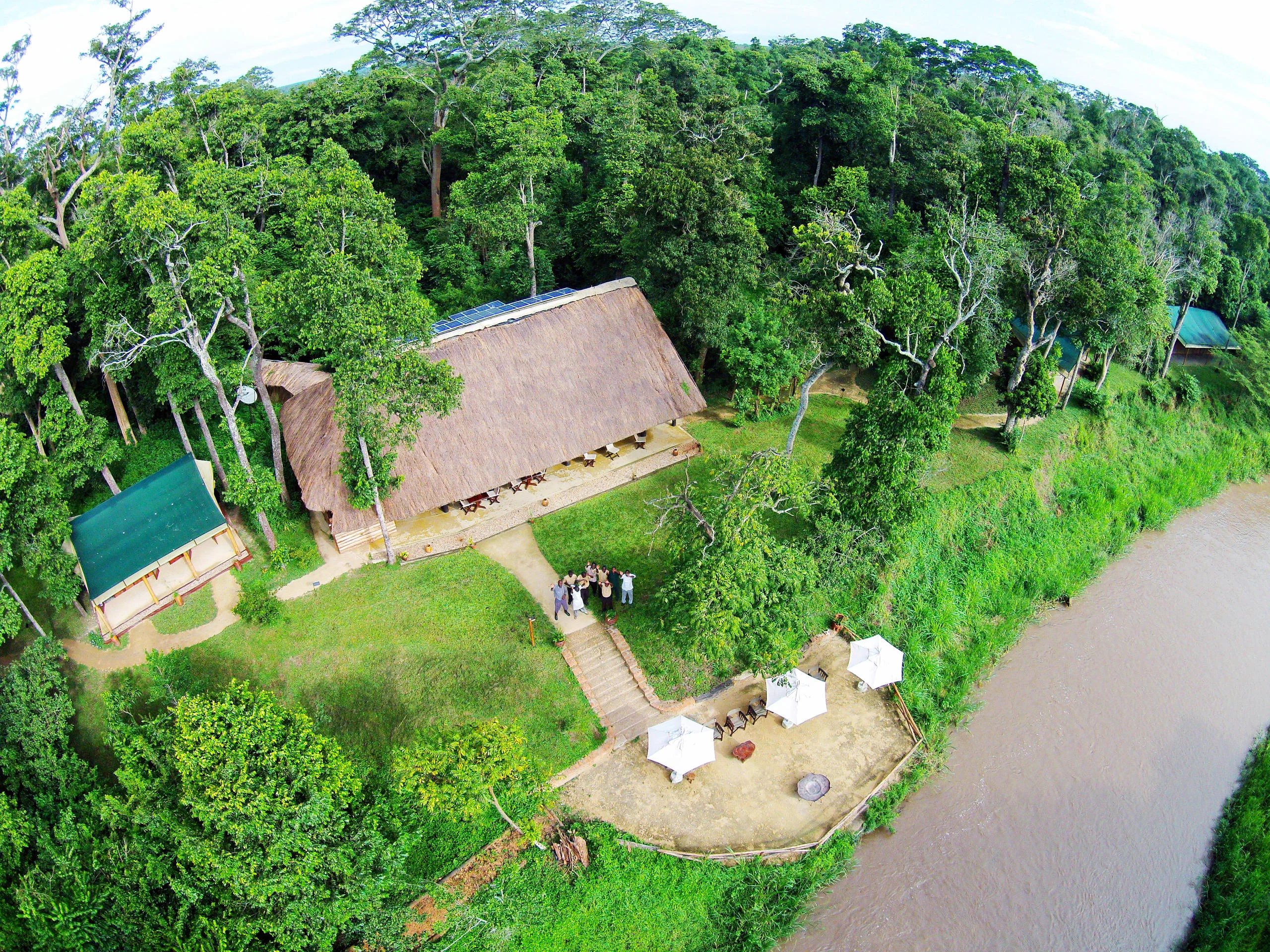 The camp beneath the trees on the riverbank, from the air