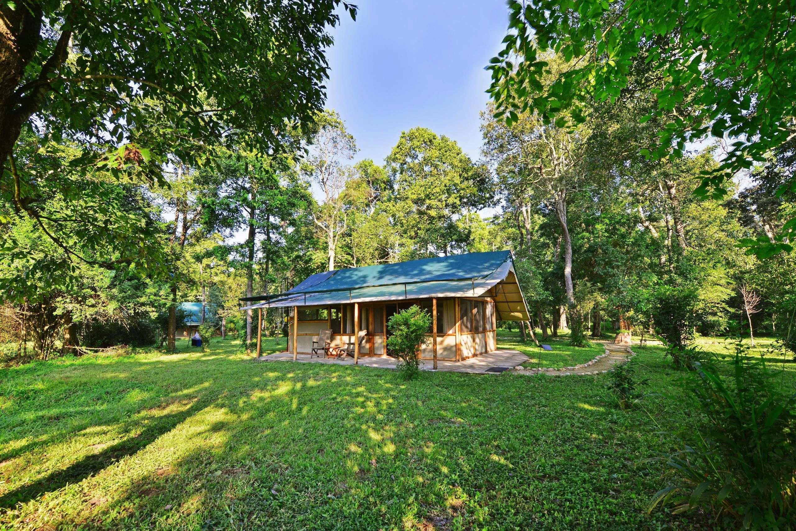 A guest tent on the lawn beneath the trees