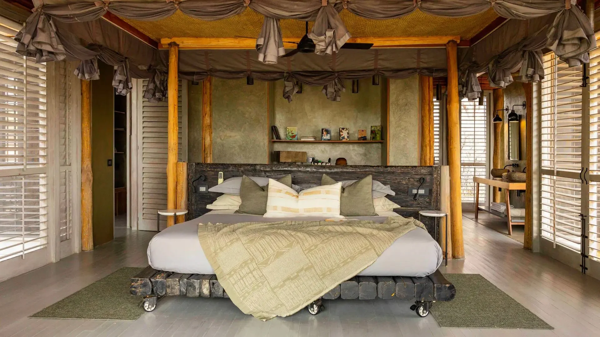 A bedroom with a canopied bed and stone walls