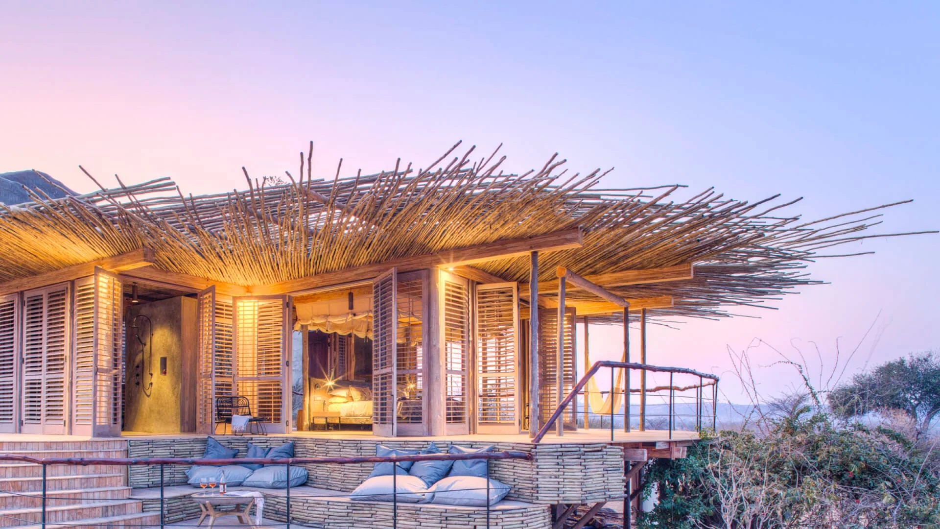 A suite with a thatched roof at dusk