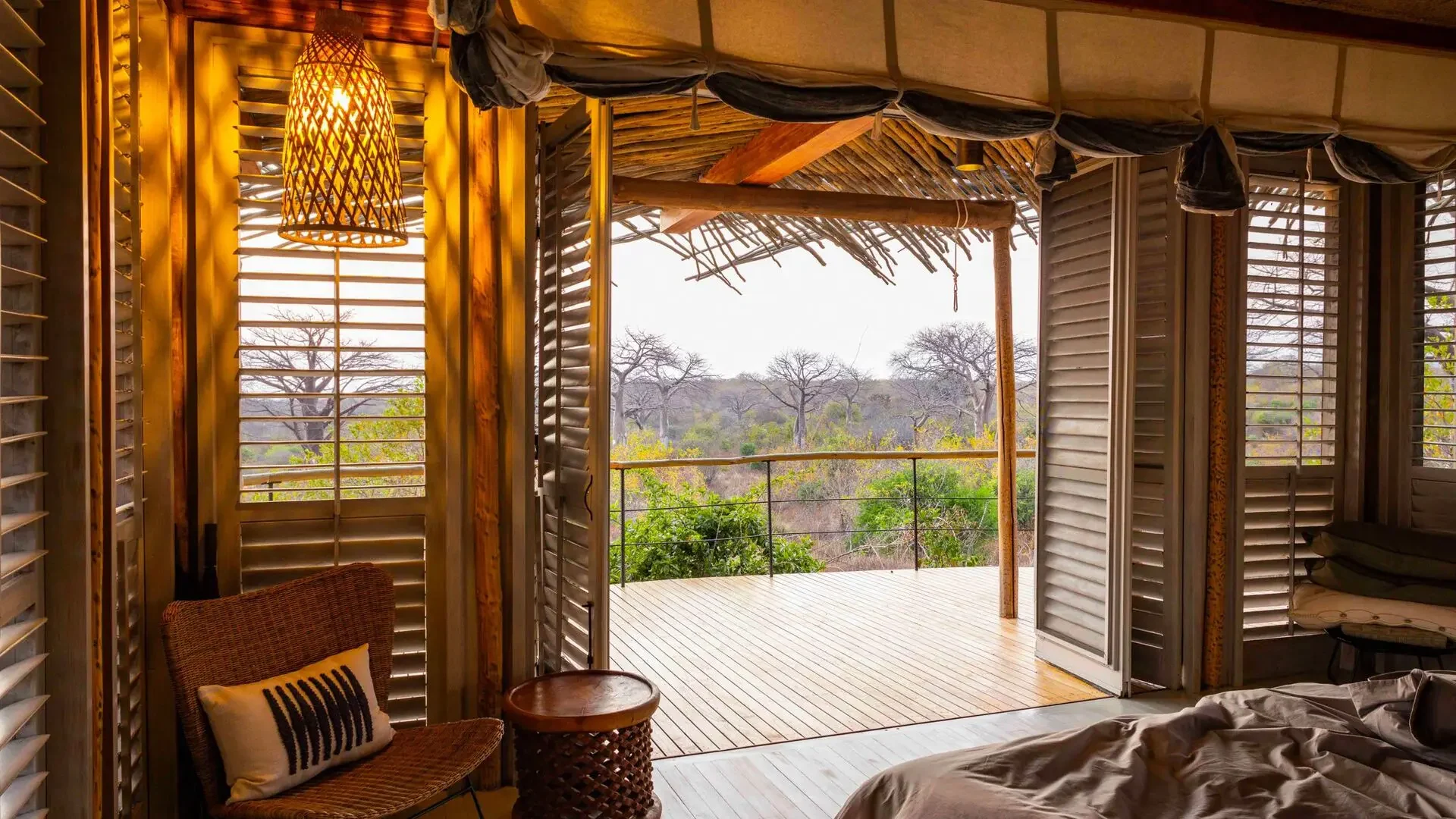 A bedroom with shutters opened to the deck