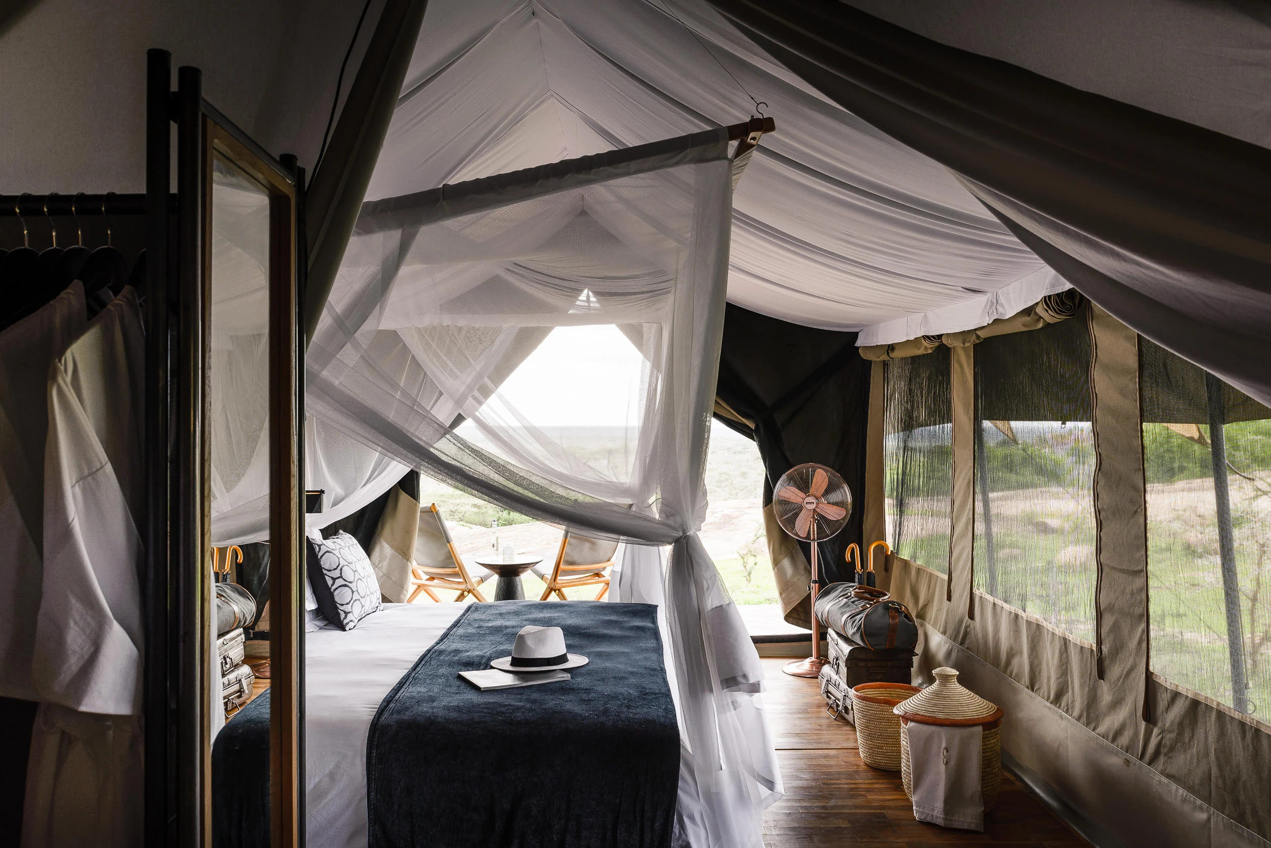 A tent bedroom with the front open to the plains