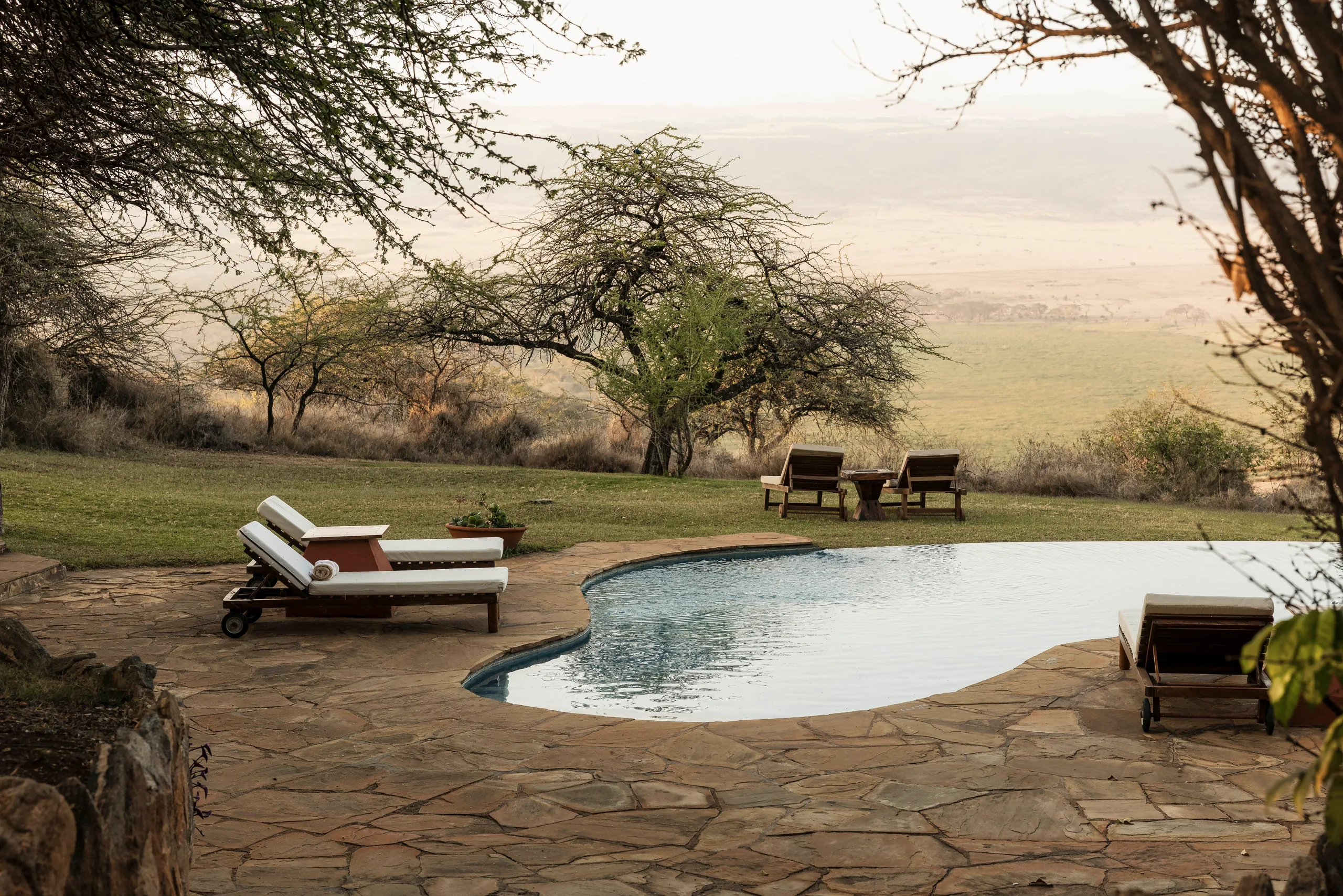 The swimming pool and sun loungers overlooking the landscape at Kifaru House Lewa