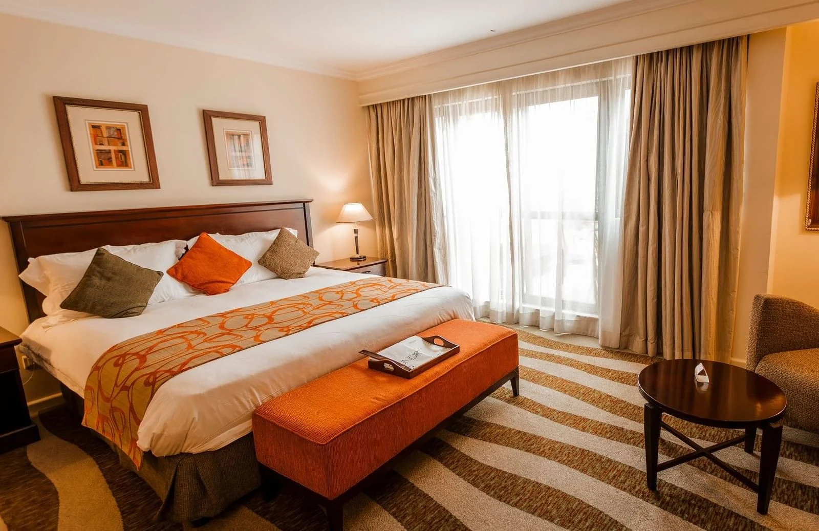 A bedroom with a double bed and an orange bench