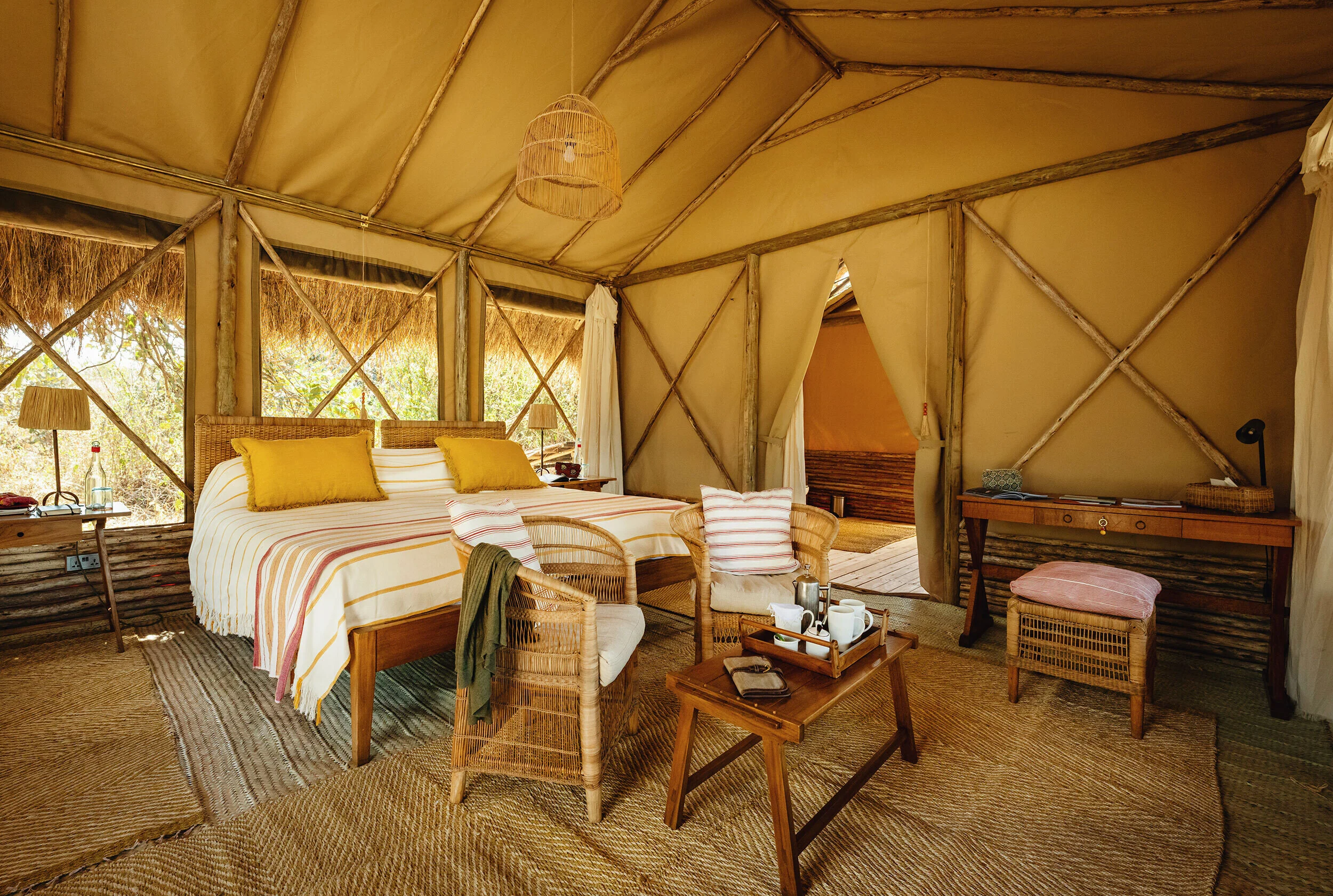 A tent bedroom with a canopy and a sitting area