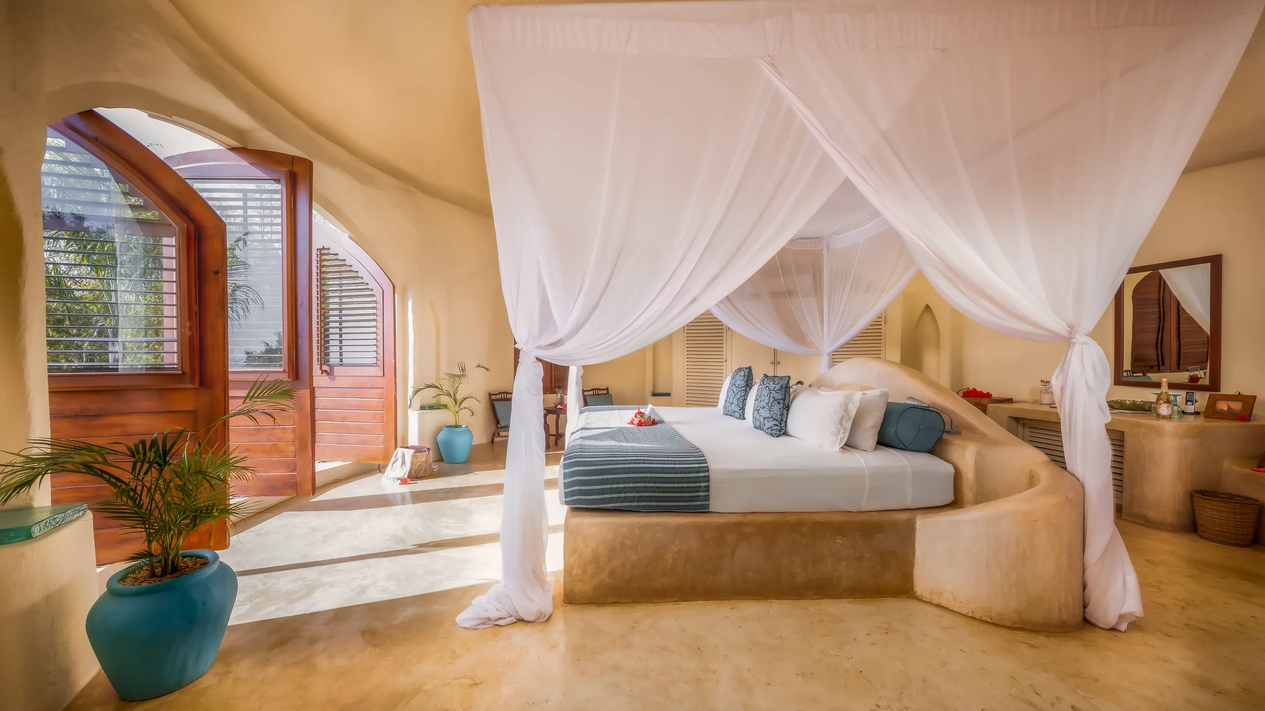 A canopied bed inside a garden-view villa at Kilindi Zanzibar