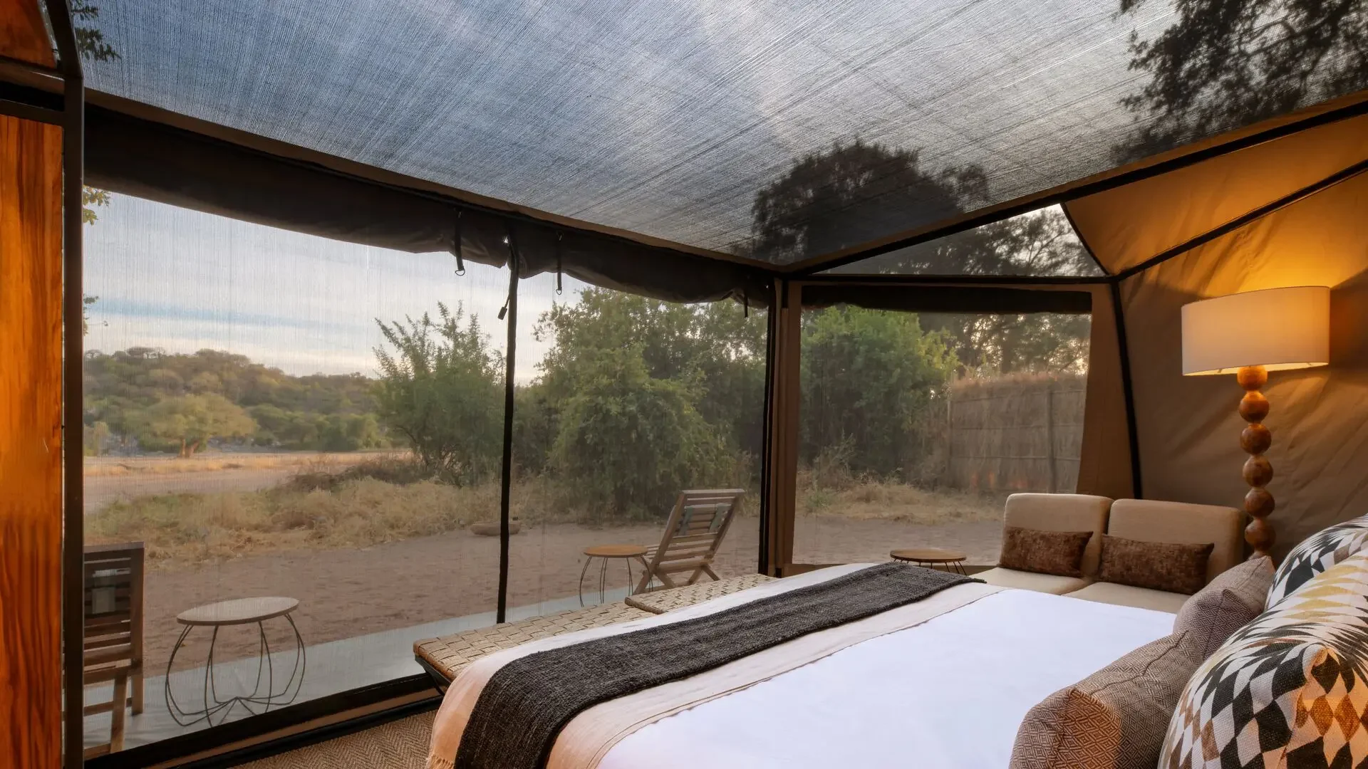 A bed beneath the mesh roof of a tent