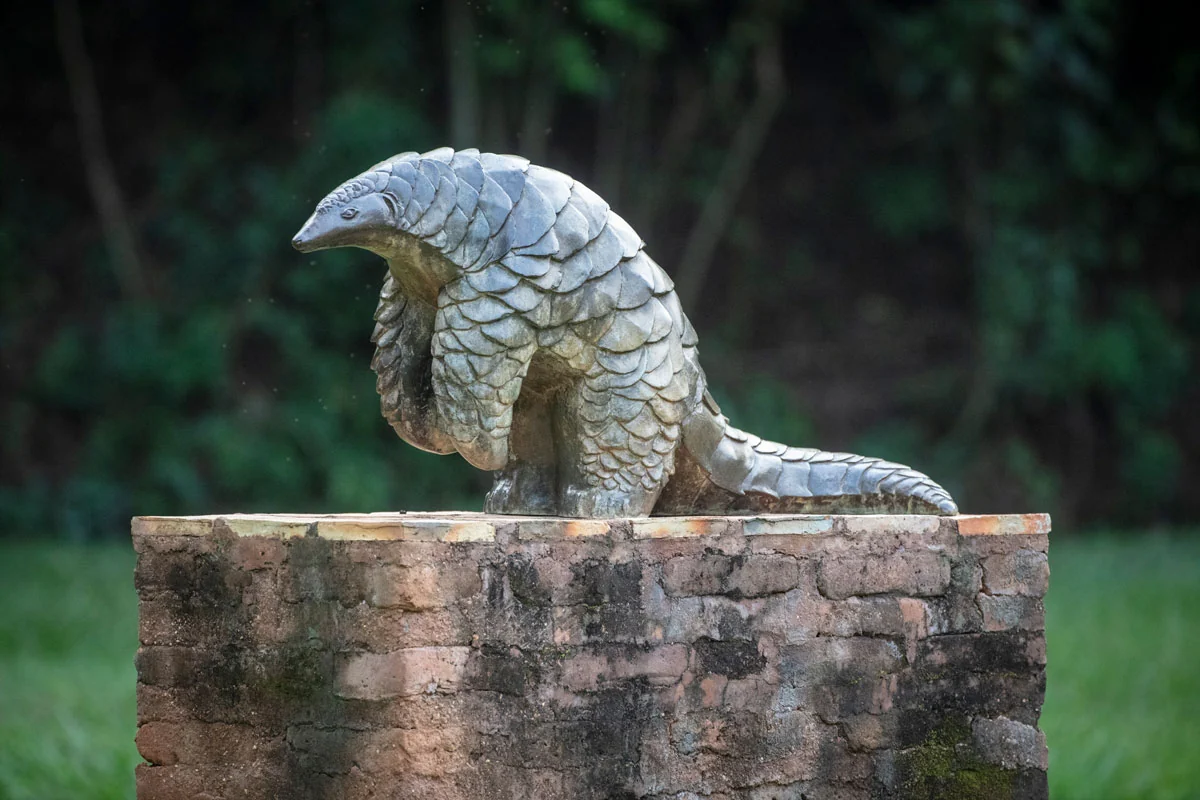 A pangolin sculpture on a brick plinth