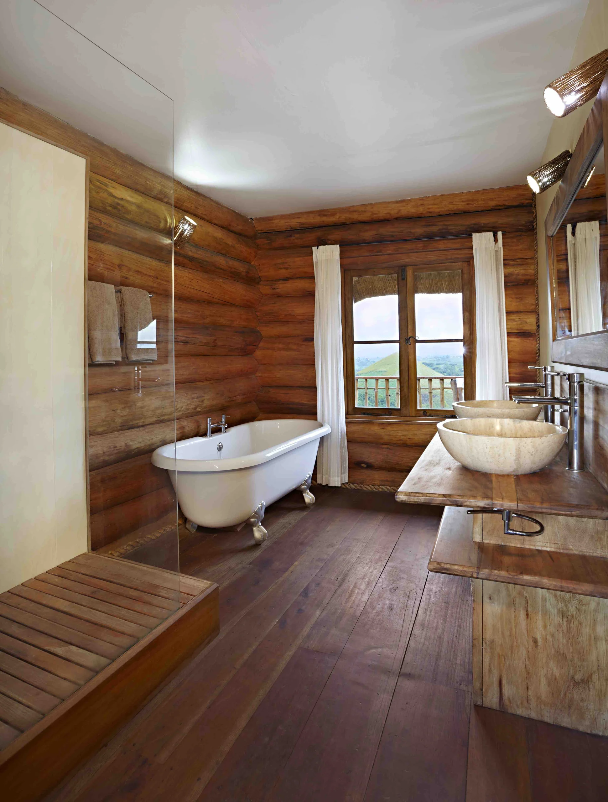 A bathroom with a freestanding bath and timber walls