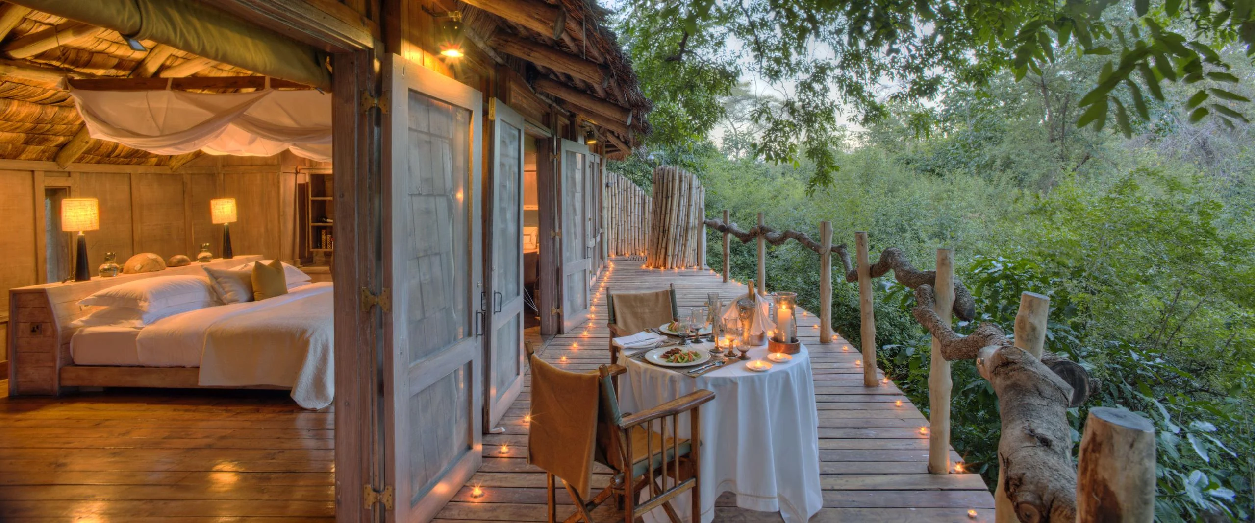 A bedroom opening onto its deck in the forest canopy