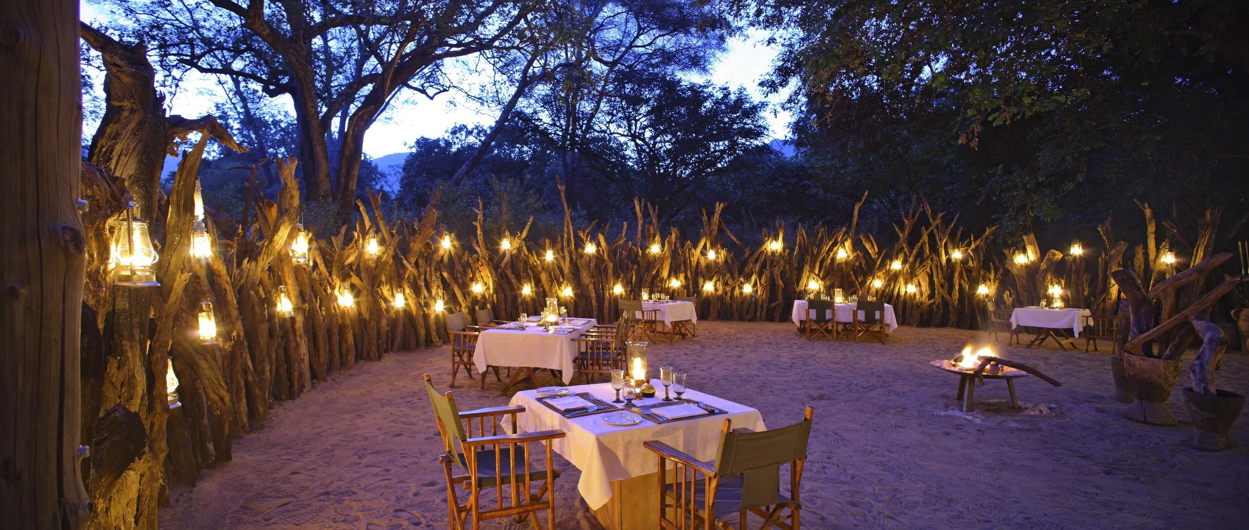 Dinner set out in the boma, lit by lanterns